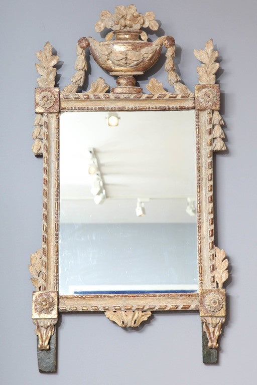 Lovely Swedish mirror retaining mostly original paint and gilding, the flowering urn finial with garland swags, the frame with ribbon and sausage and bead carved edges, the corners with flower head bosses and foliate carved festoons, the whole with