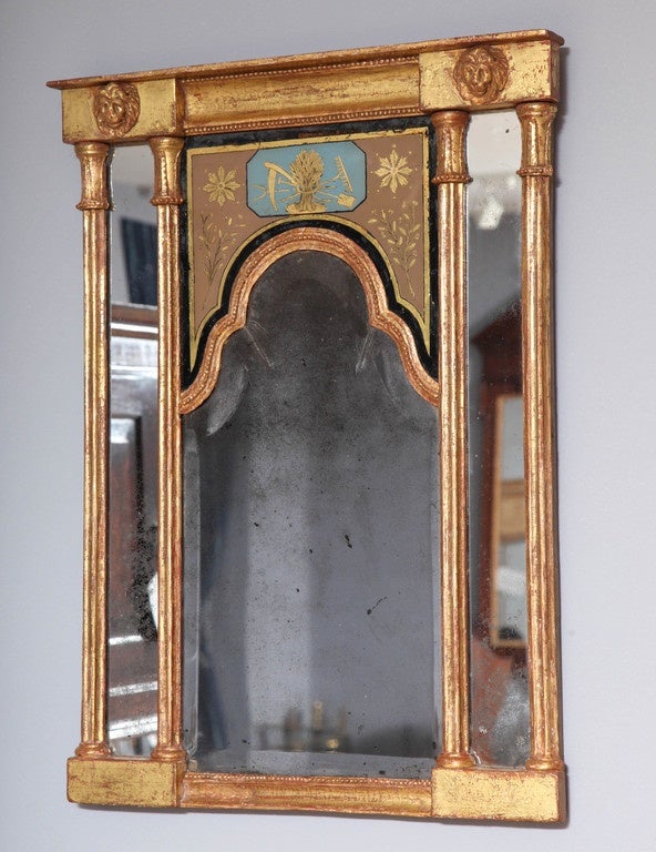 There is nothing new about recycling. This early 19th century English neoclassical giltwood and églomisé mirror is a little gem, made all the more interesting because it was fashioned around an arched beveled mercury glass plate that already 100