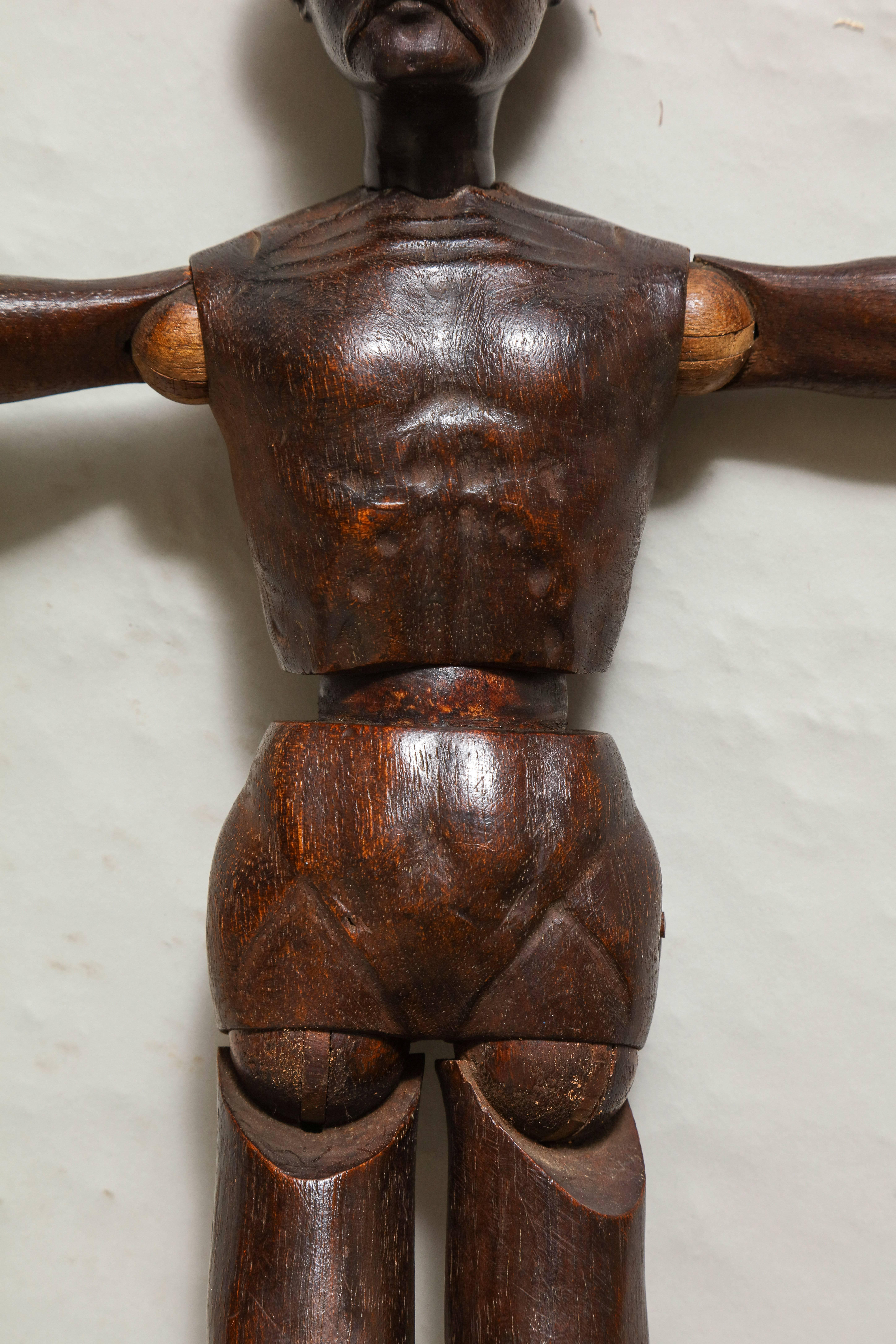 Early 19th century carved walnut artist's model, unusually carved with full head of curly hair and mustachioed face, the limbs articulated and possessing good rich patination.