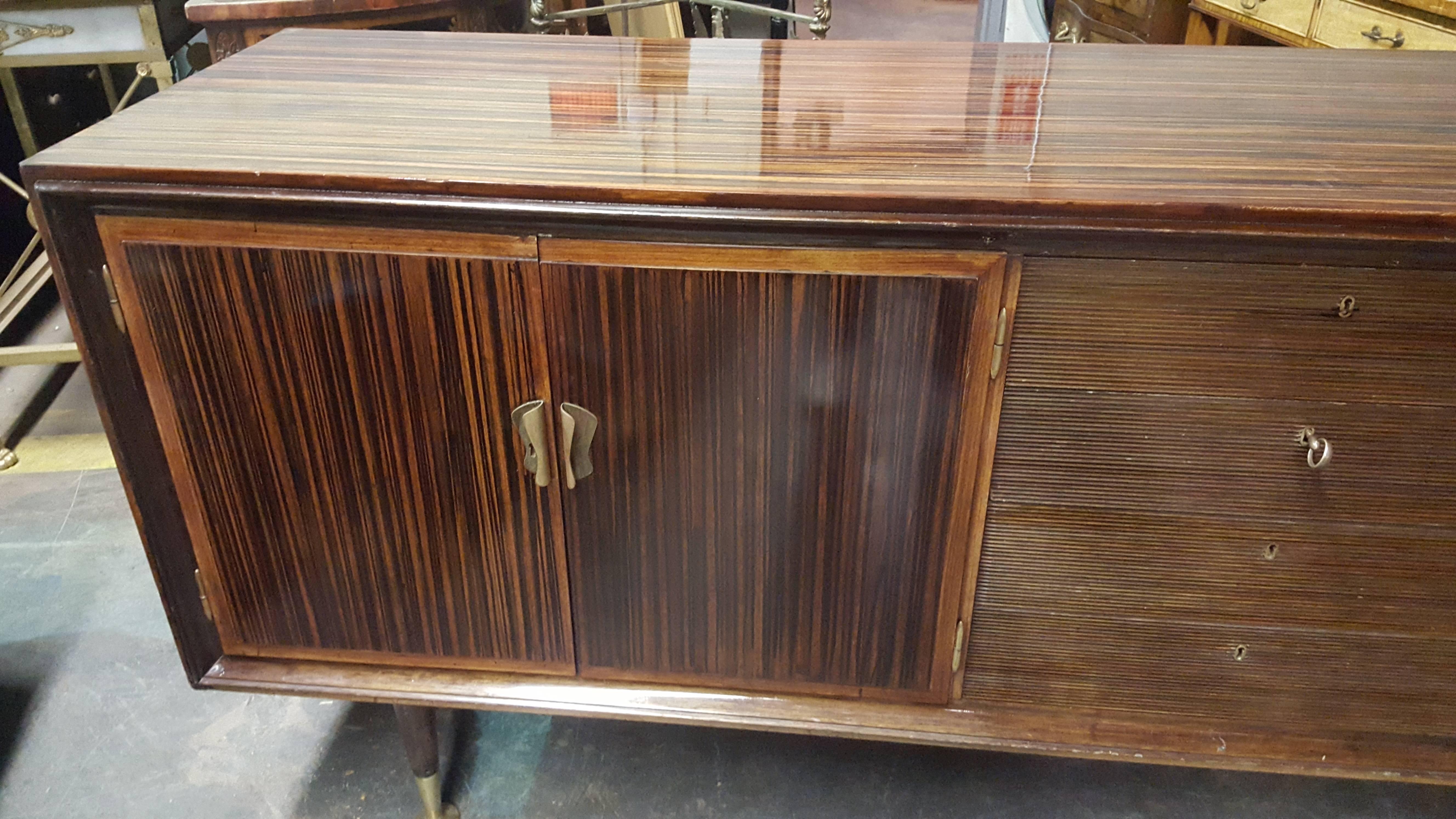 Faux Macassar ebony sideboard with reeded central drawers, bird's eye maple interior fitted with shelves.
