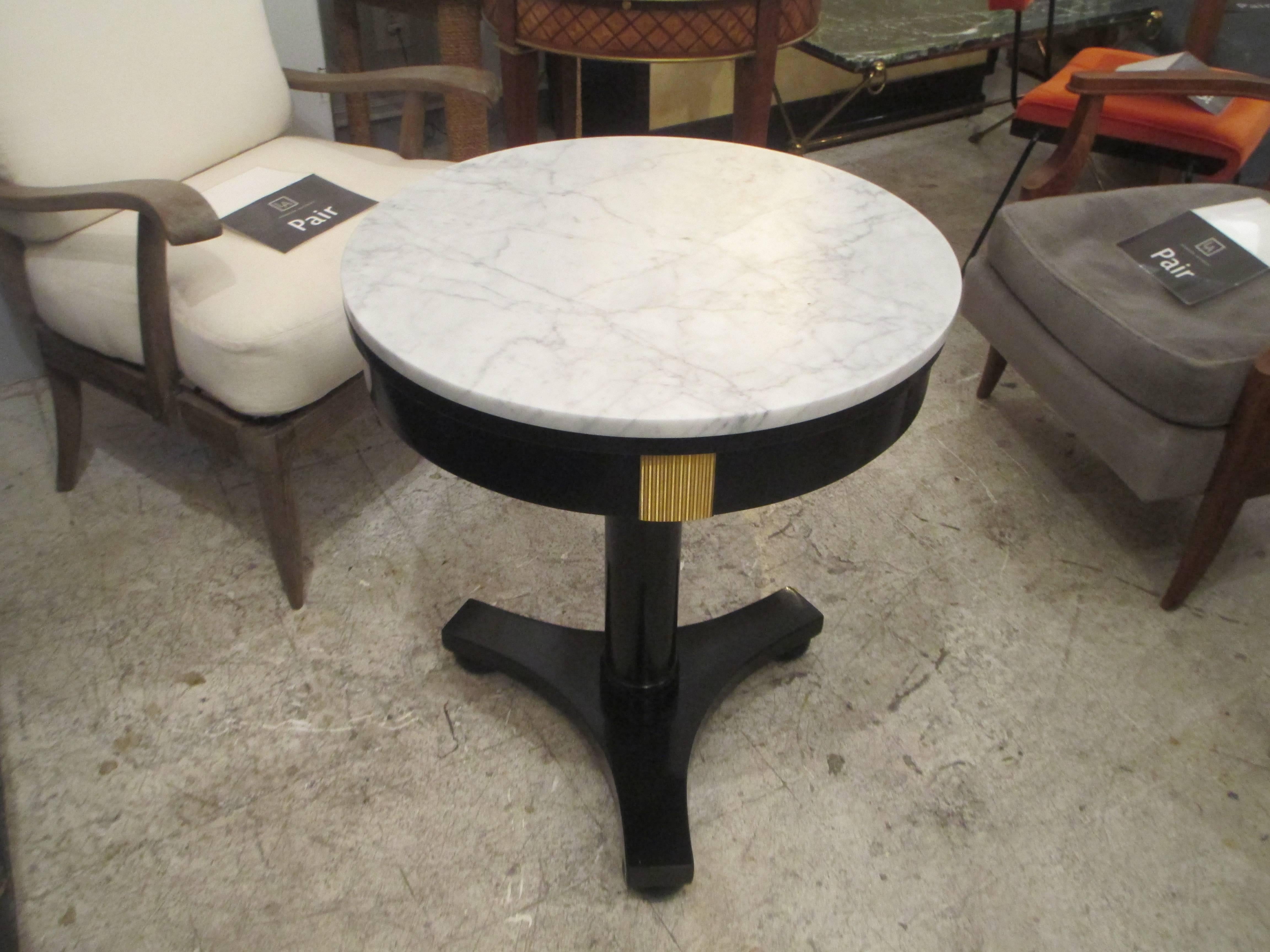 Ebonized marble top Empire-style gueridon table with brass mounts.