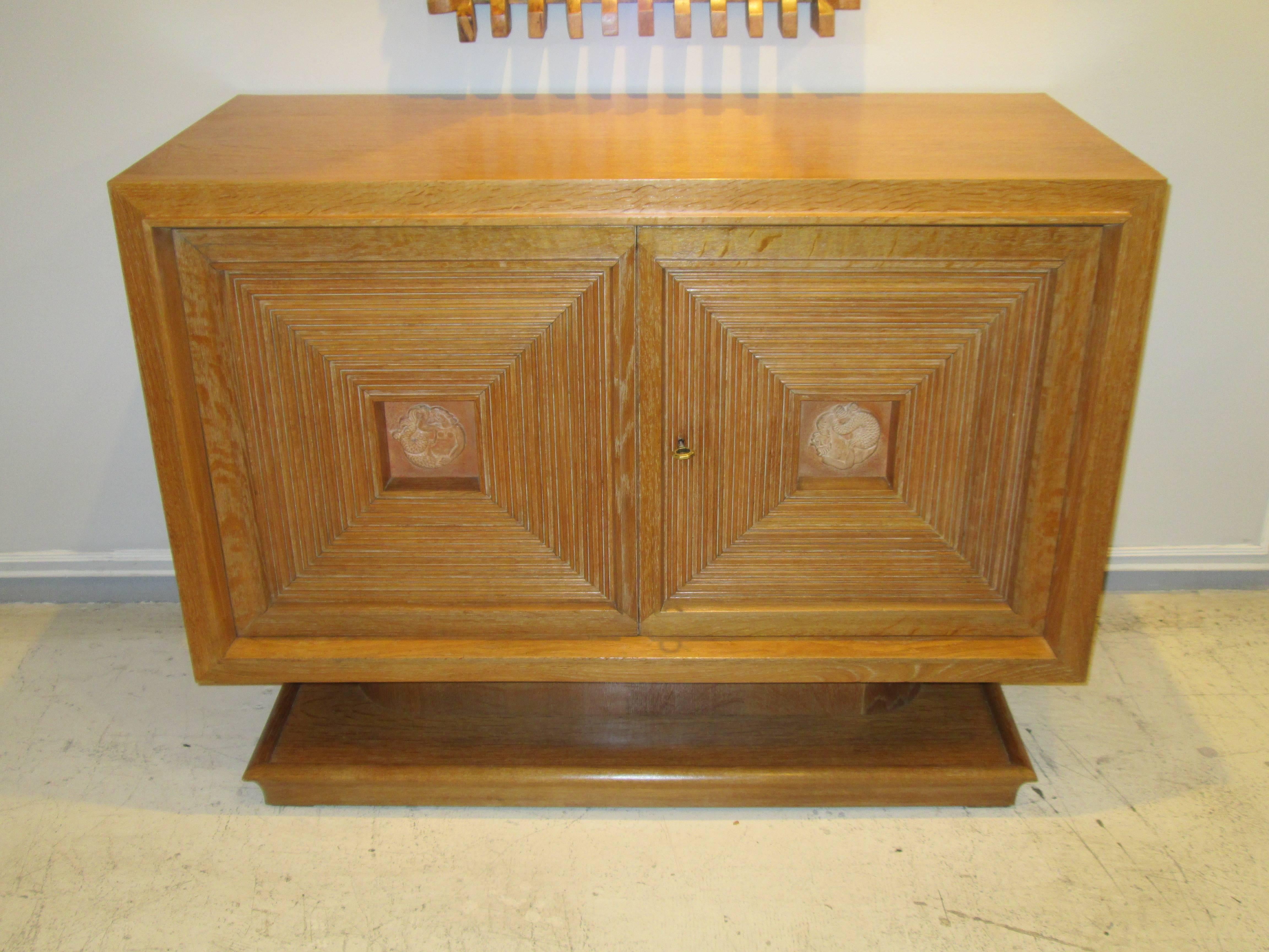 Sculptural  Cerused-Oak Sideboard attributed to Maxime Old  With Two Central Doors Each Featuring Central Ceramic Plaques on a Plinth Base

Maxime Old was born December 13, 1910 in Maisons-Alfort, a suburb of Paris, and was the son and grand-son