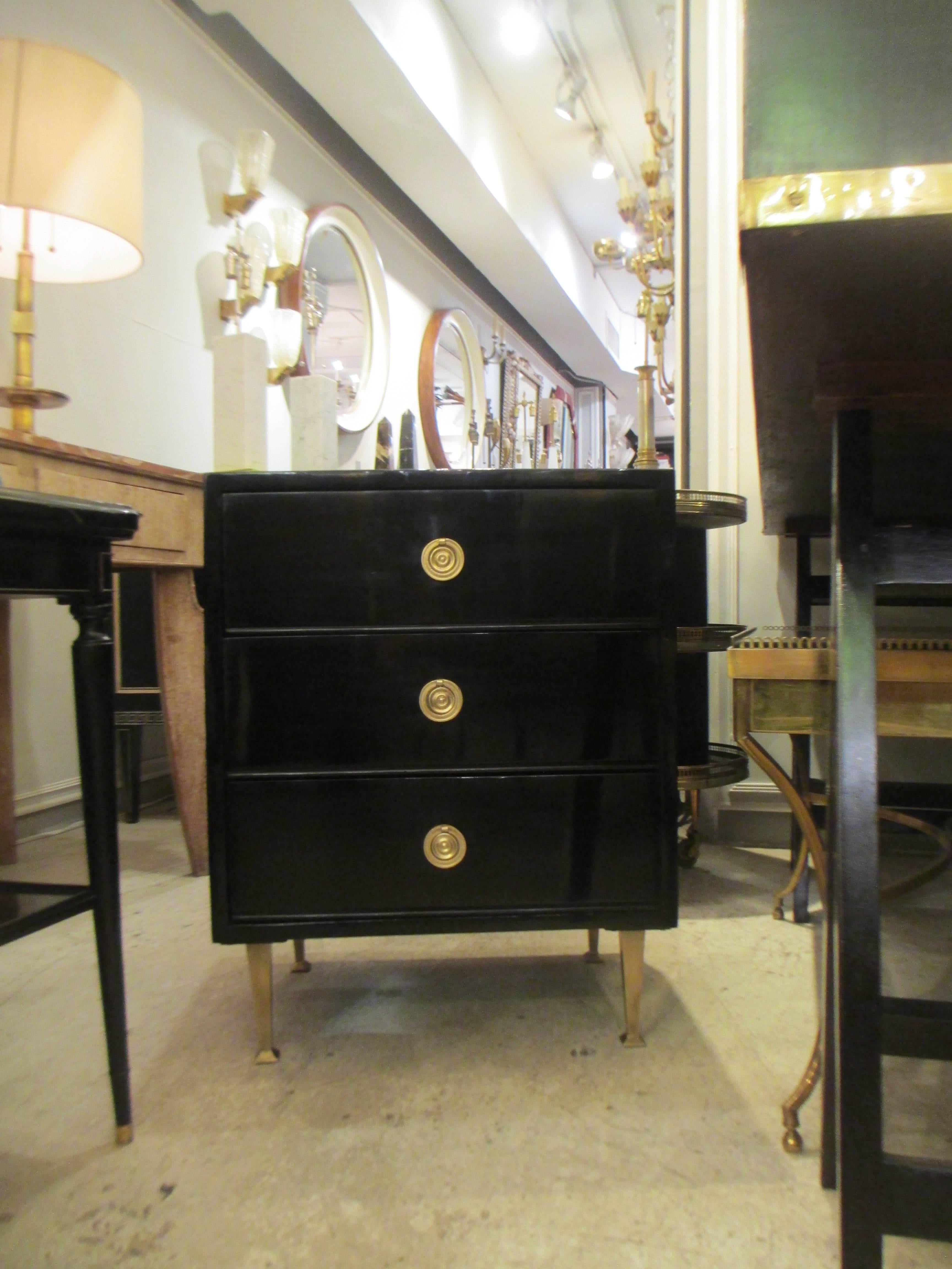 Pair of Mid-Century lacquered nightstands in the neoclassic manner on brass feet with three pull-out drawers.