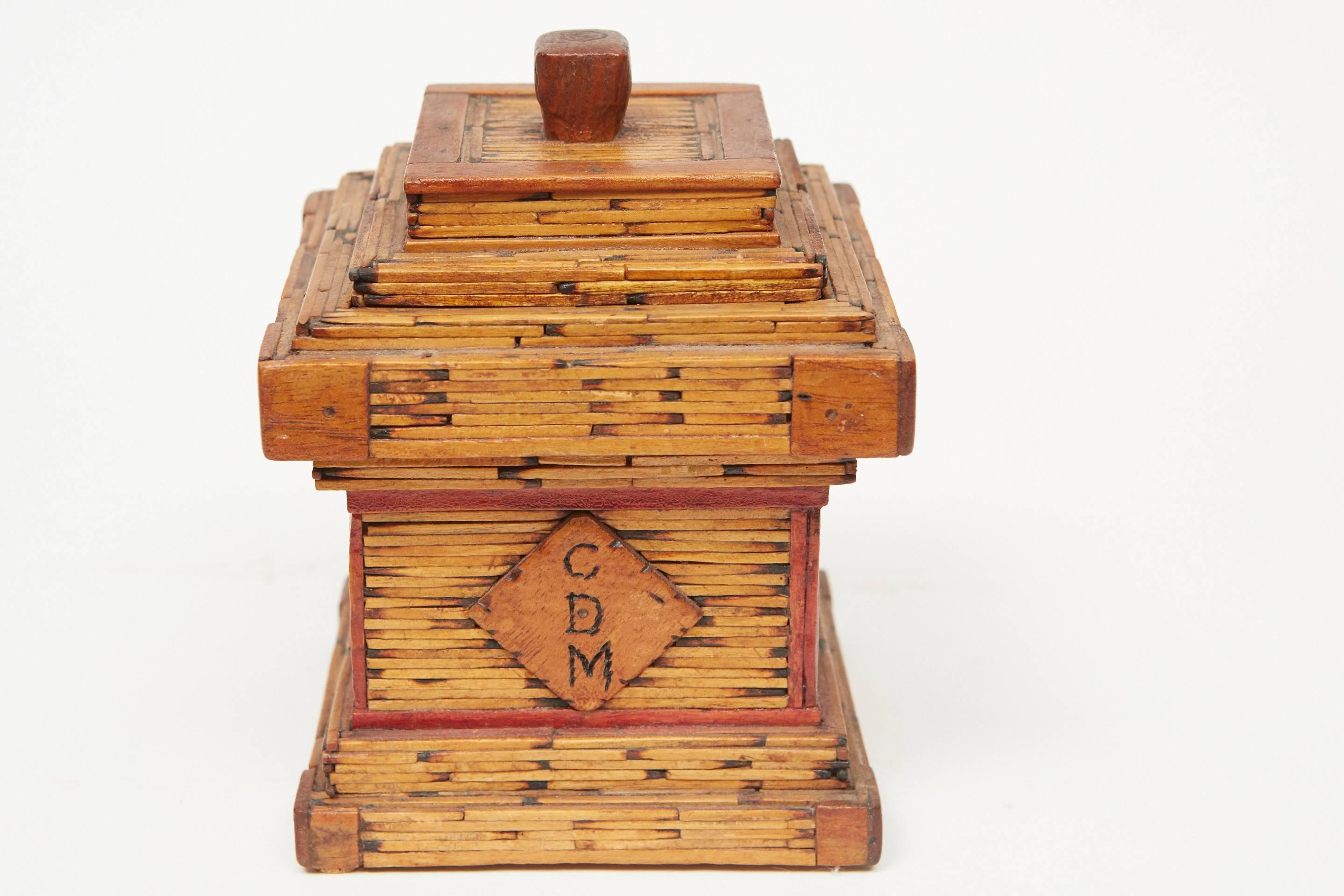 This matchstick box is a great an example of American Folk Art, handmade with simple materials, this piece has exquisite details and an interesting design. The body of the piece is made from painted crate wood evidenced by the commercially printed
