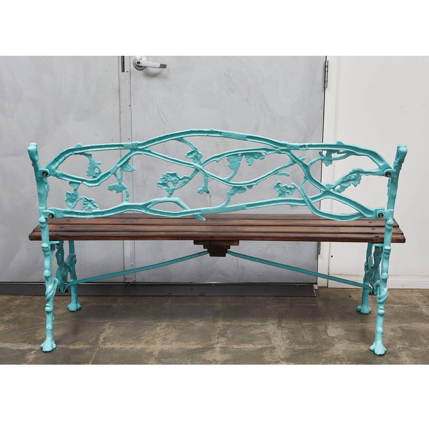 This English Victorian garden bench has been styled and re-furbished for a second life. The iron base has incredible decorative elements of oak branches, leaves and acorns with entwining serpents creating the lower legs and stretchers. The base has