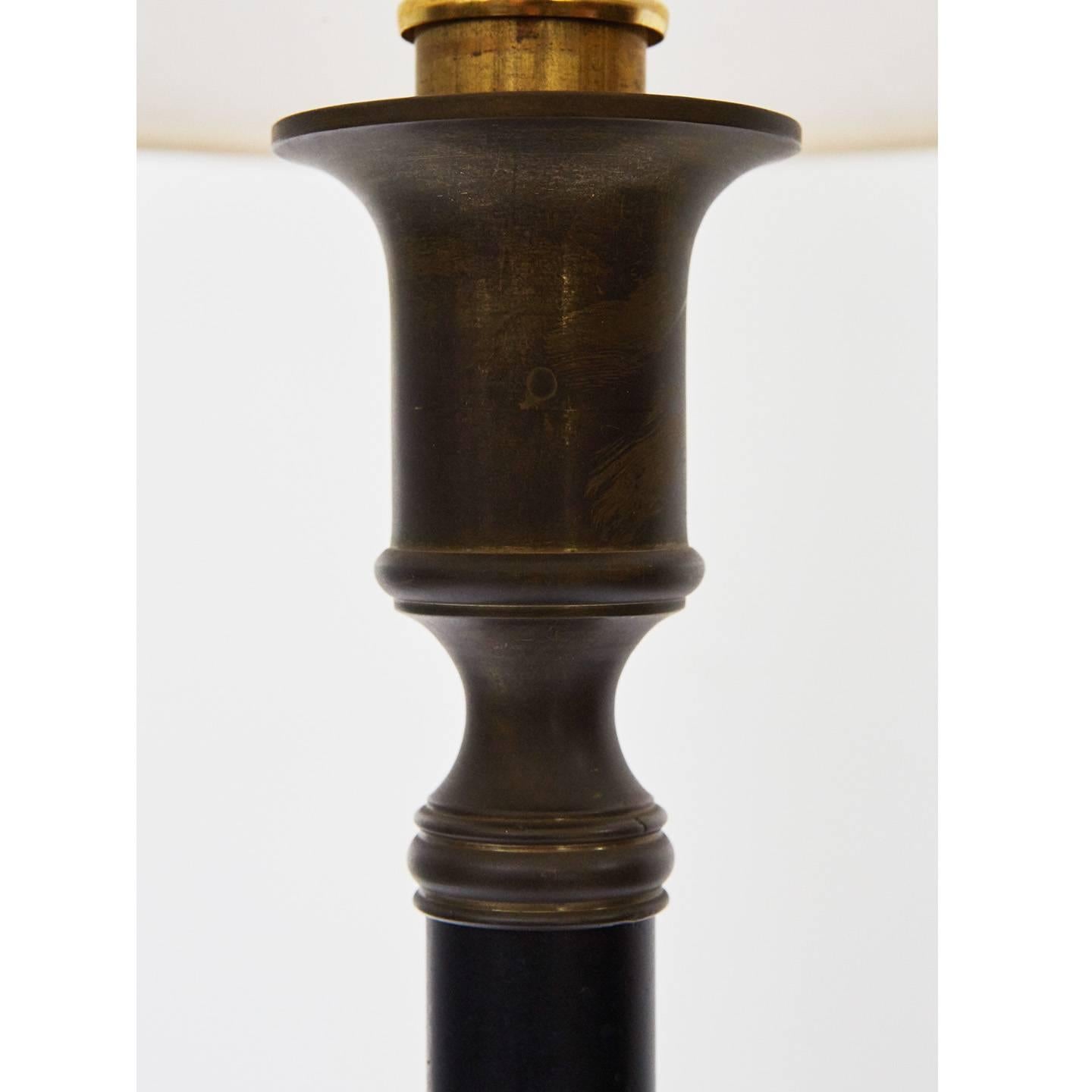 These distinguished lamps are made of metal on wooden bases with natural patina and signs of age and wear. The pair are of a nice size, well-proportioned and of a nice height. The lamps have been recently re-wired and are ready for use. These lamps