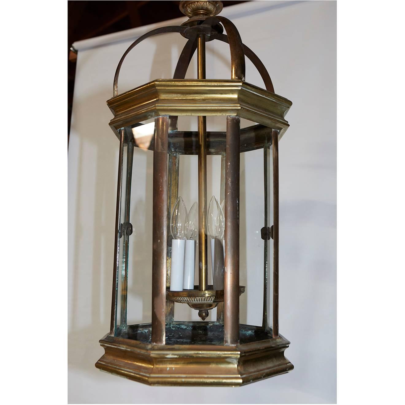 This pair of original English lanterns were gas lamps converted to electricity with four candle stick lights. They are quality crafted in solid brass with brass plating and removable glass panels. The lanterns have been recently re-wired for US