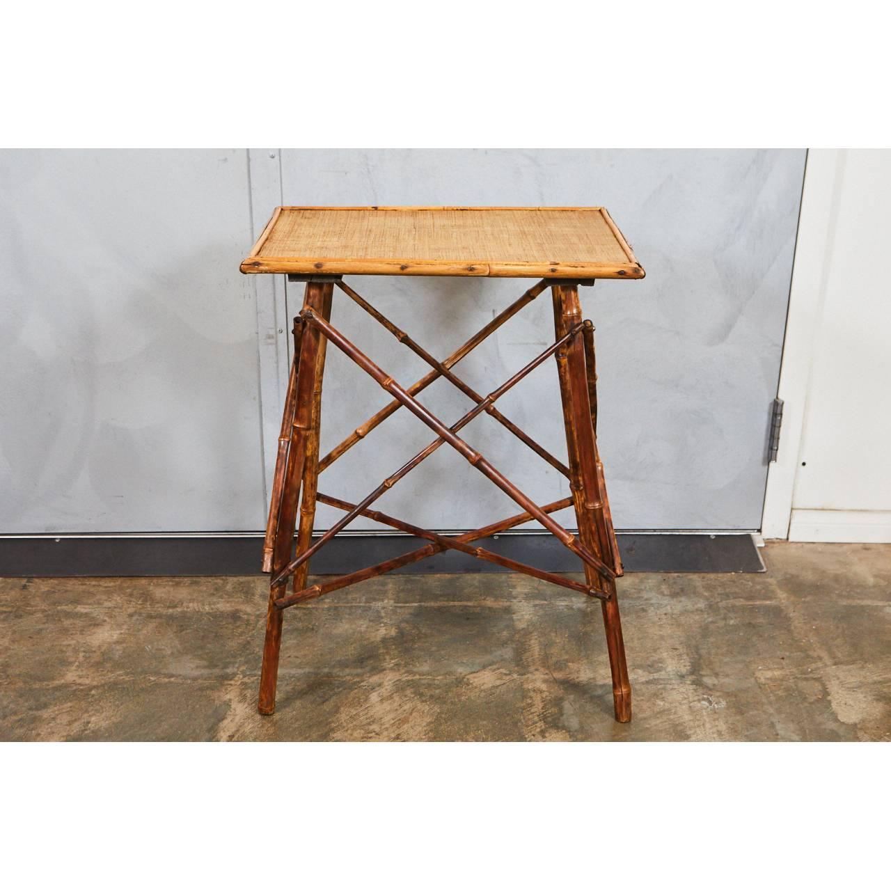 This small side table is a classic Victorian tiger bamboo piece with interesting crossed side supports and stretchers. The bamboo legs and supports have been reinforced with wooden dowels. The top has new waxed cane matting.

    