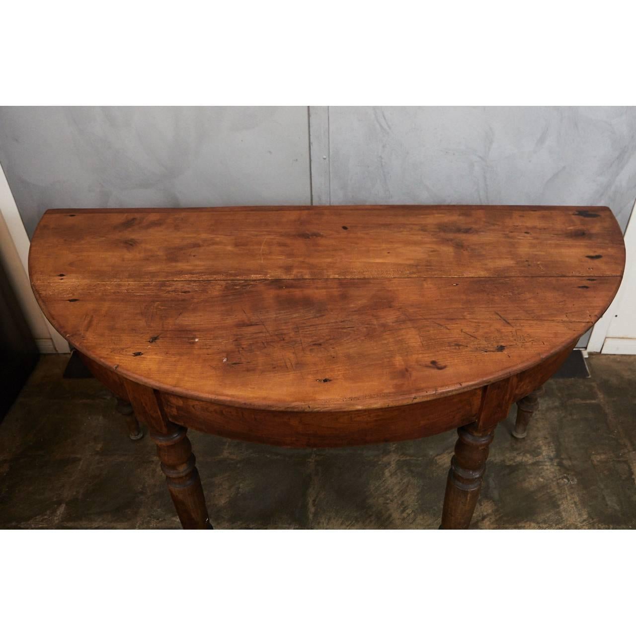 This mid-19th century American table is a well crafted piece of country furniture. The table has four handsomely turned legs that taper to the floor. The table has nice signs of wear indicative of its age.