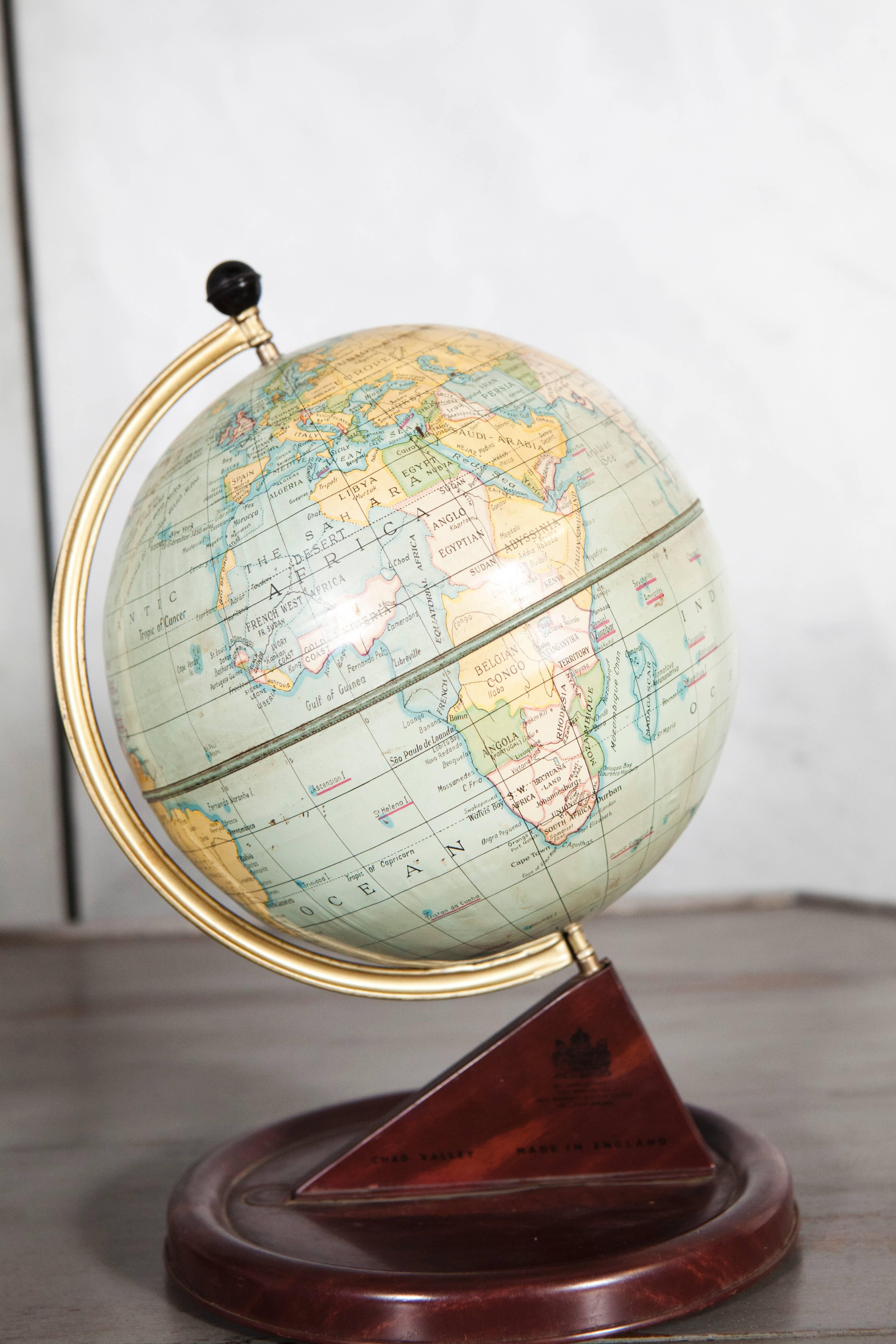 This child's globe has the maker's label from Chad Valley Toy Company in England. This 1920's globe and has nice art deco design elements with wood grain painted metal surface of the bases. An excellent decorative item for a variety of settings this