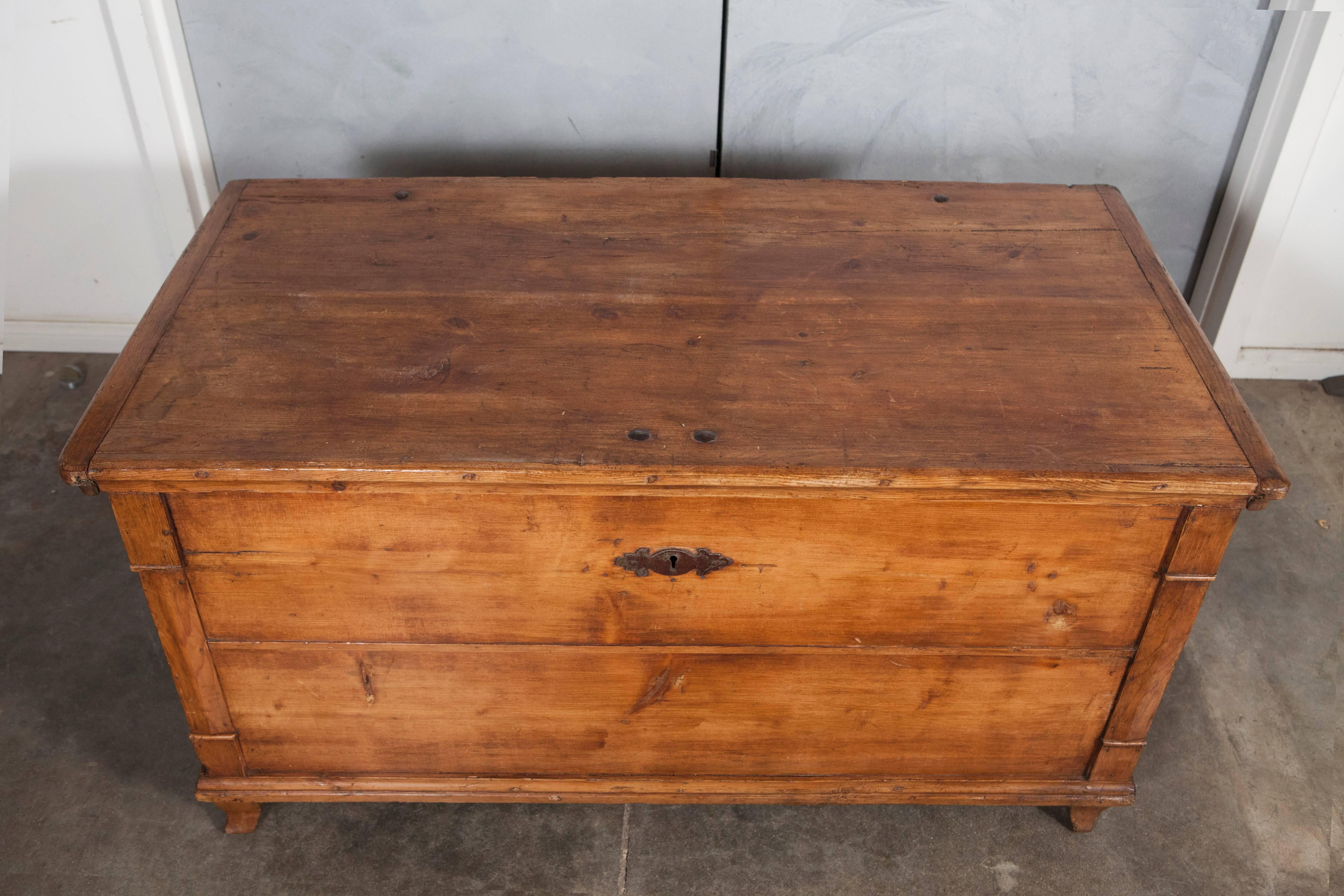 This antique pine trunk is a great piece with full candle box, iron strap hinges and handles. The trunk has nice moulding details and stands on four-shaped feet.
 