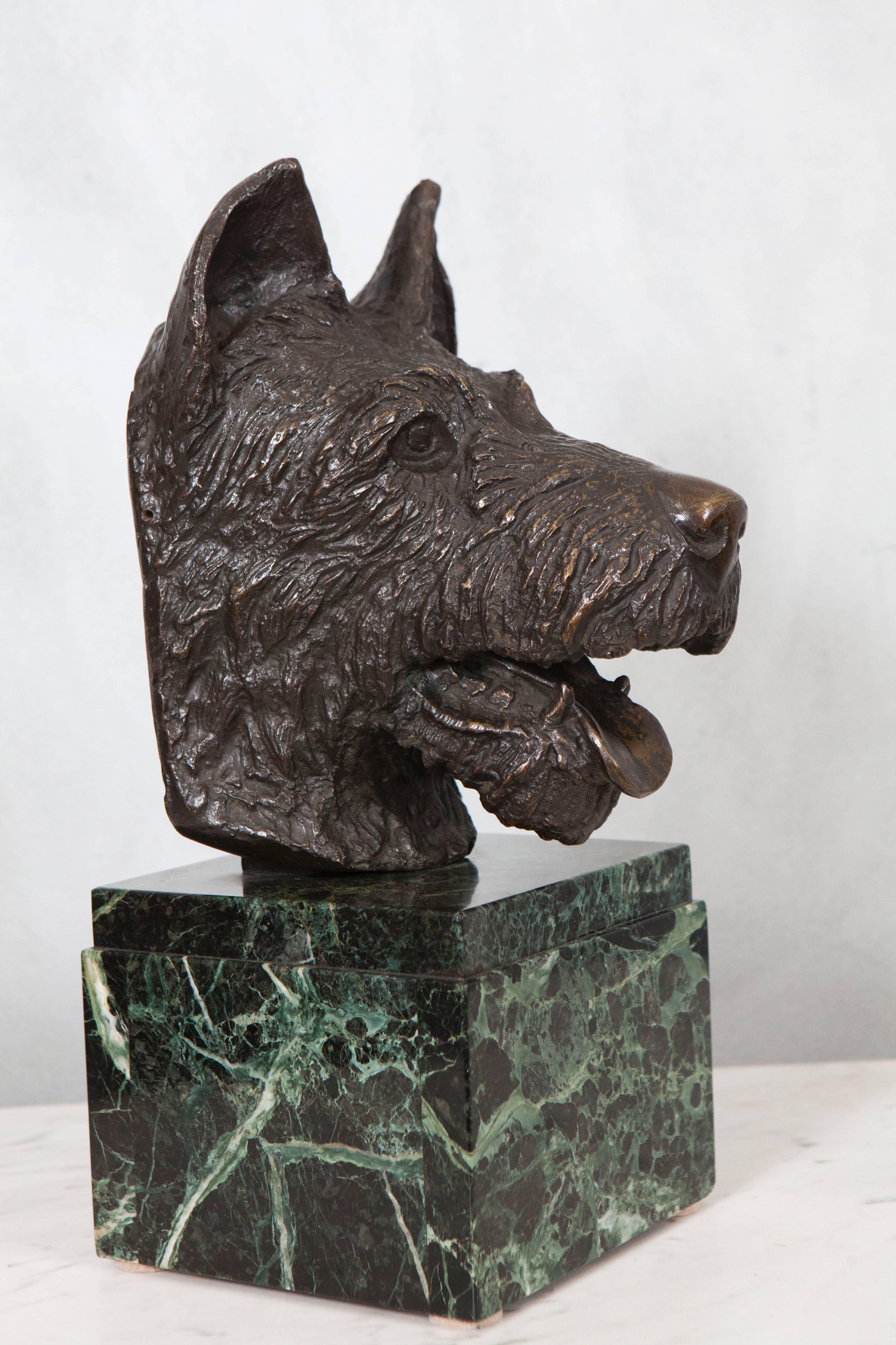 A delightful dog statue in bronze sits on a stepped marble block base. The detail of the casting and expression of the subject is something we love. This bust of a perky terrier will bring interest and delight to a variety of settings.