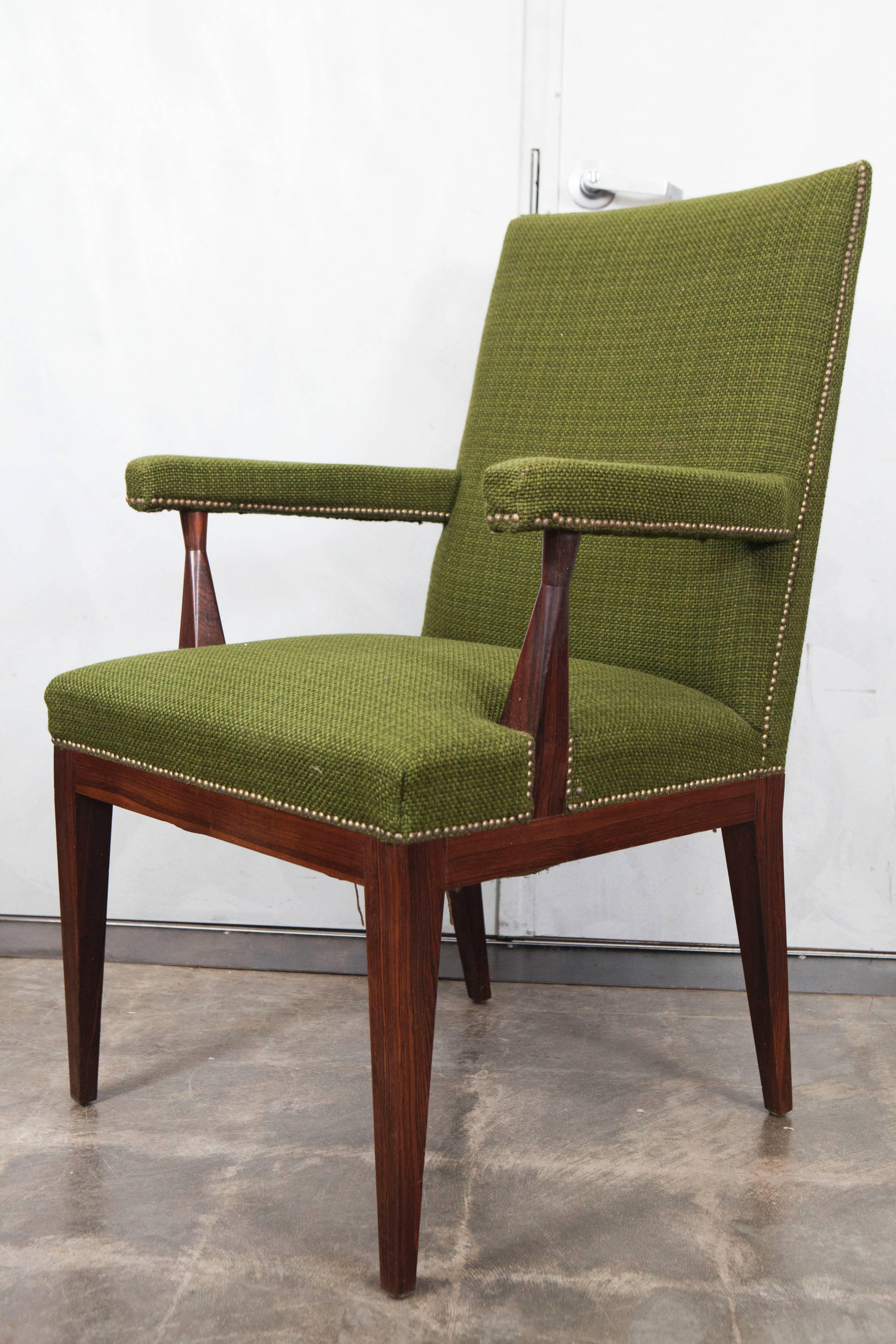 This pair of Mid-Century armchairs are made of rosewood and upholstered in a vintage green fabric. Based on their style and materials we believe they were designed and produced in Scandinavia in the 1950s. 