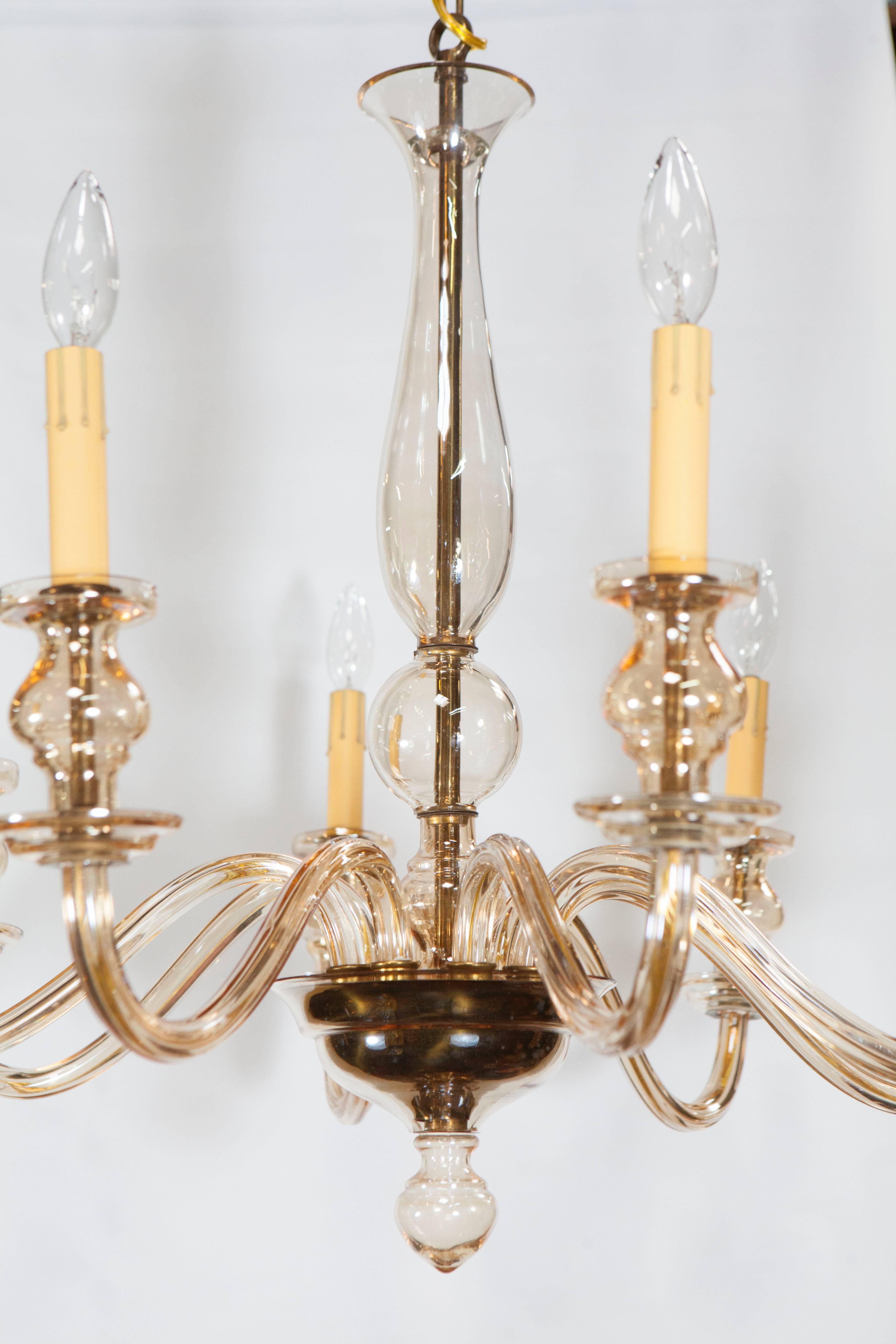 This Murano glass chandelier is of a good size with subtle amber coloring. It has eight arms, each with blown glass holders and and candle stick light fixtures. The chandelier is recently re-wired and ready for installation. Height measurement below