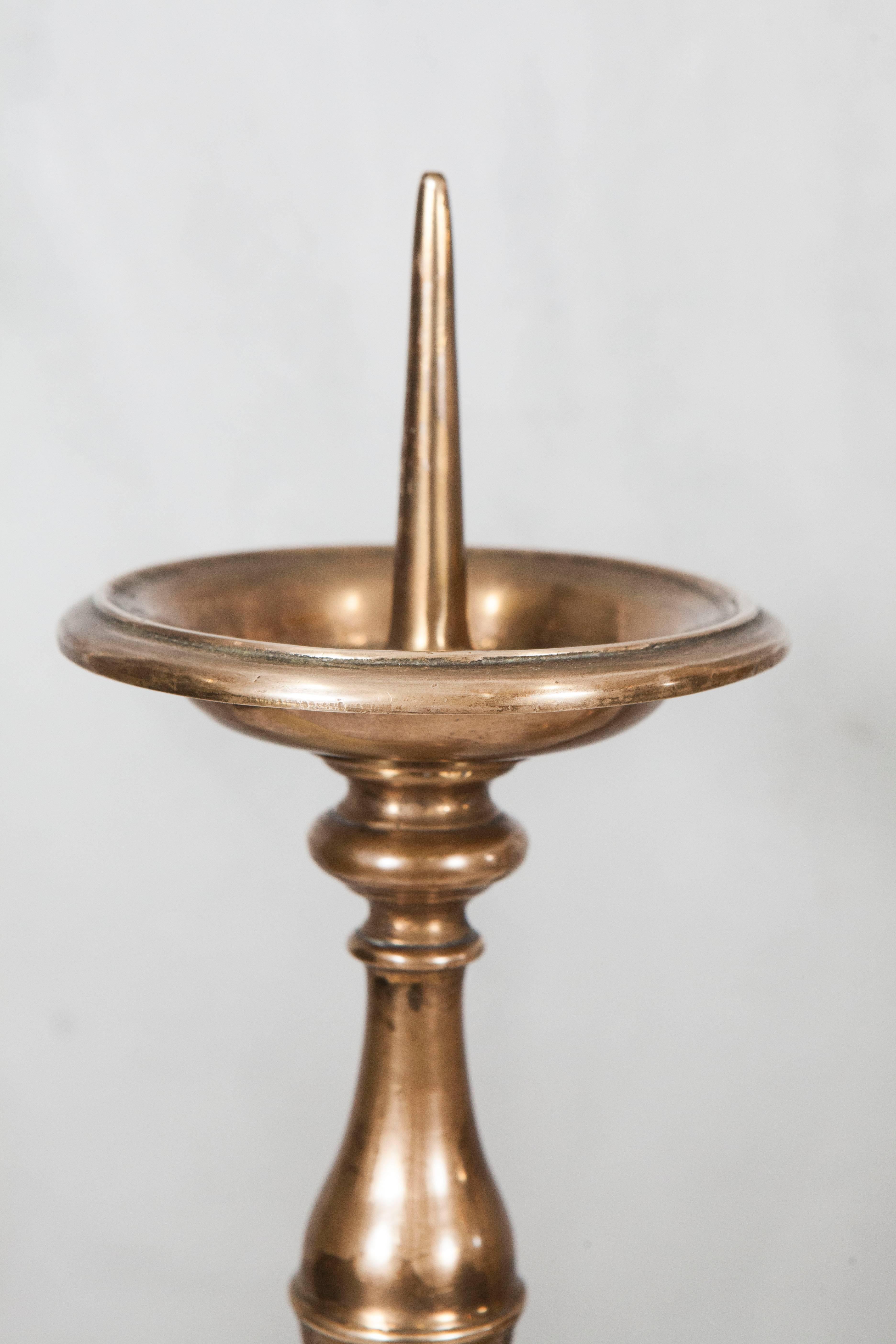 Pair of Dutch brass pricket candlesticks from the 19th century in an earlier style with upswept drip-pans raised on turned baluster and egg-knopped stem, with triangular step moulded weighted bases supported by ball feet.

