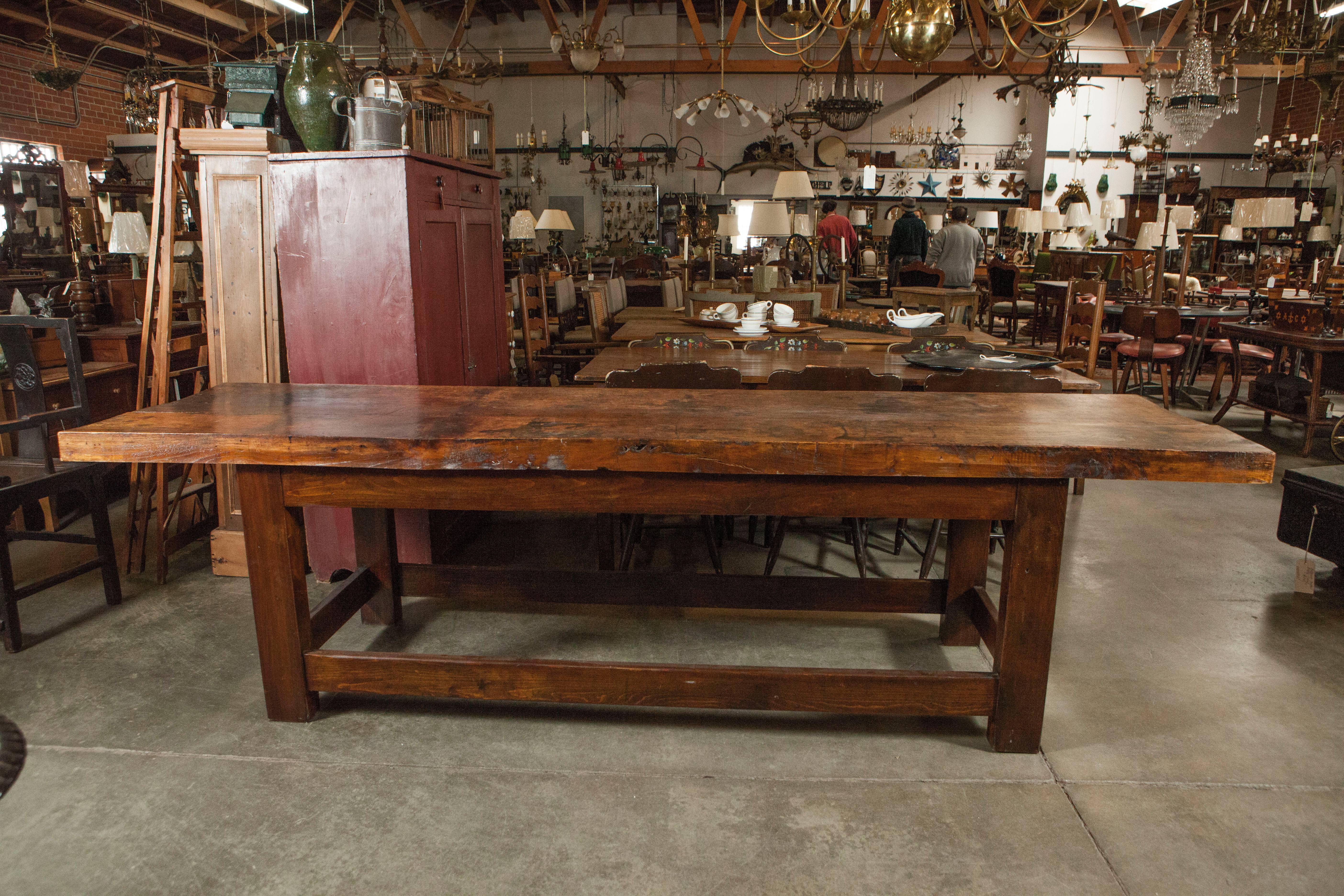 This substantial piece of antique furniture has a two board, 3" thick table top, attractive squared legs and stretcher bars. Thought to have originally been used as a work table this piece would also work well as a dining or console table in a