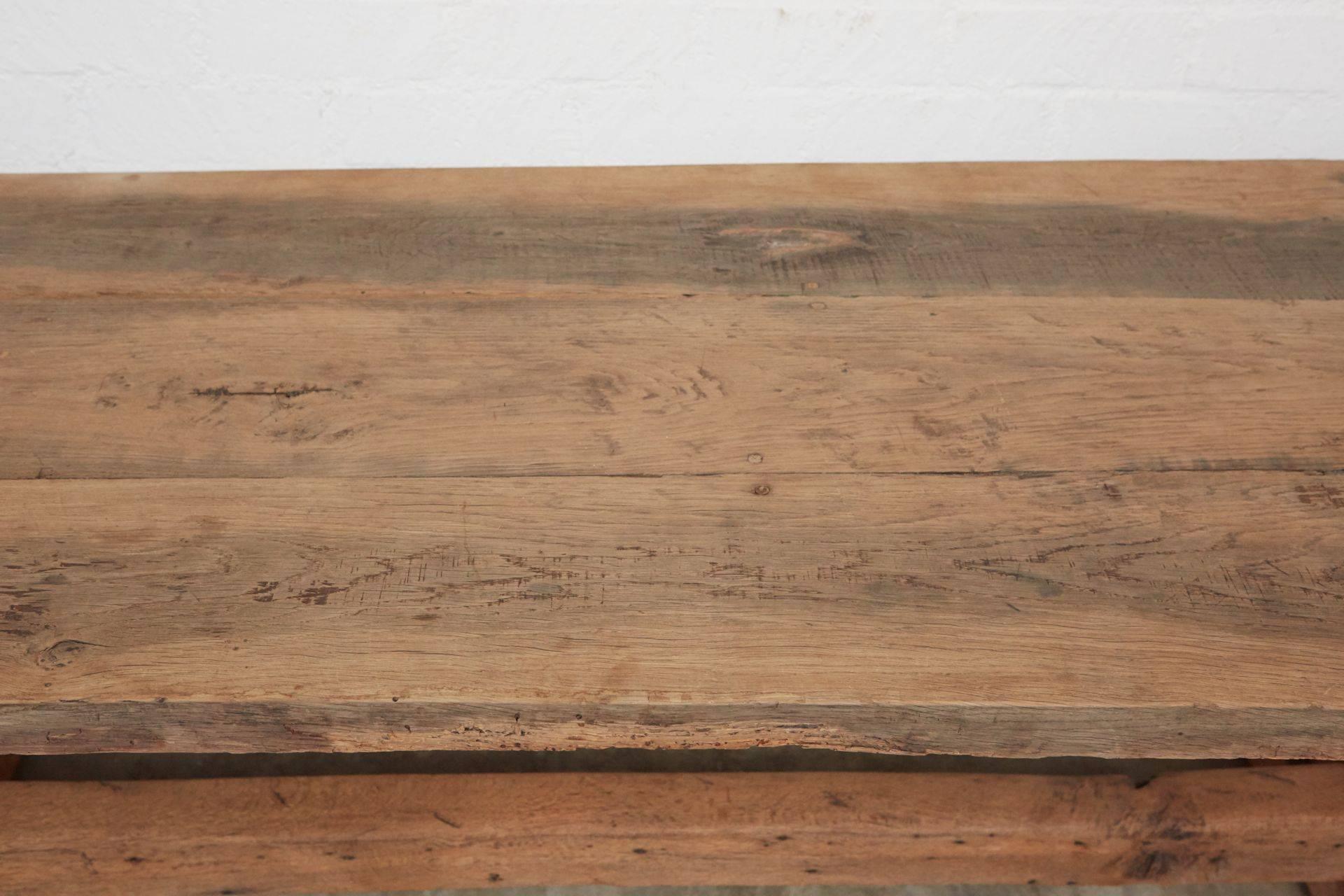 This beautiful, large trestle table has old world craftsmanship and a preserved rustic patina that exemplifies it's age and use. The three board top is 2" thick.