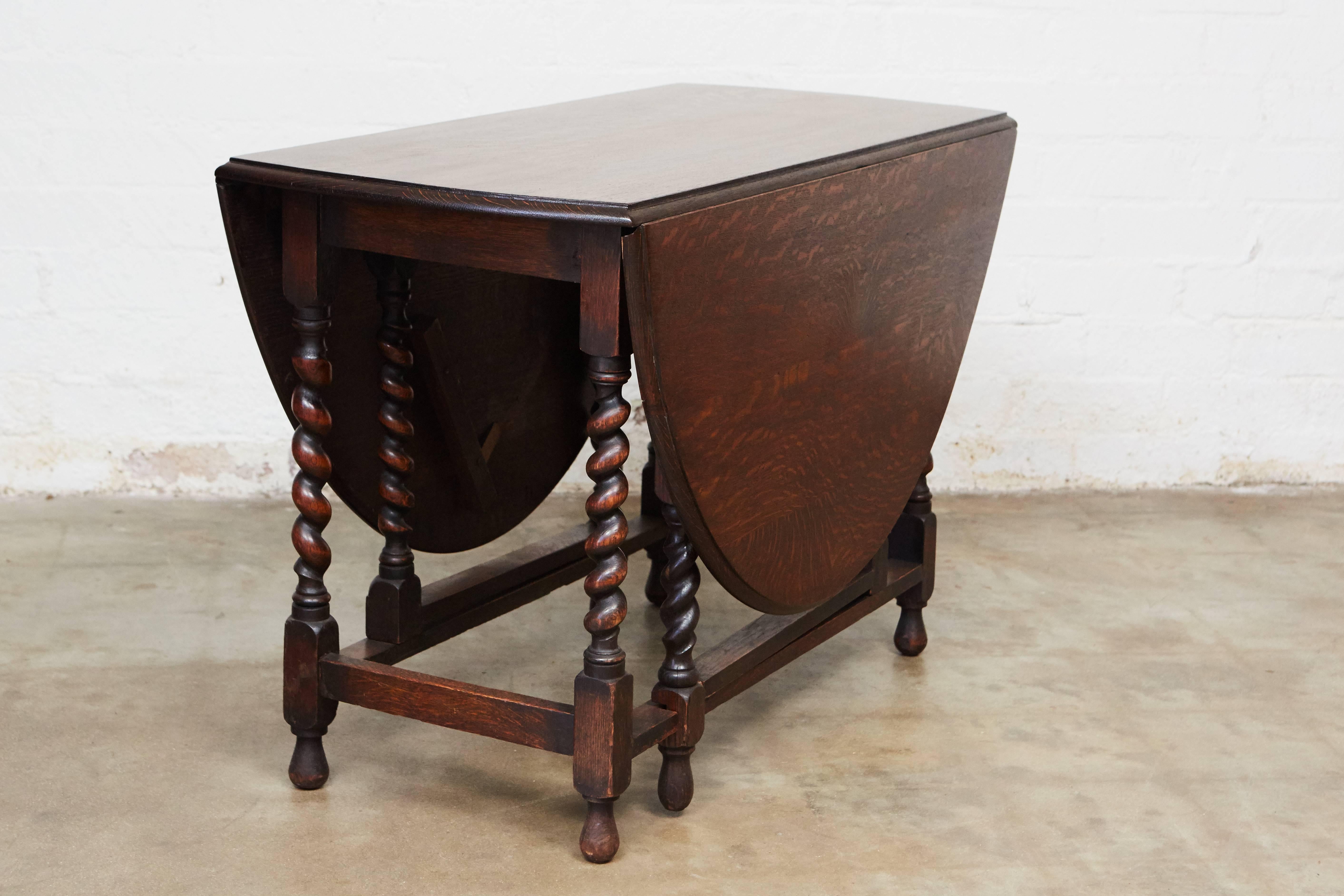 This pretty gate leg table is adjustable with an oval top when opened and a narrow rectangle when closed. Note the excellent craftsmanship with beveled edges on the table top, four stretchers and elegant barley twist legs. 

Measurements for table