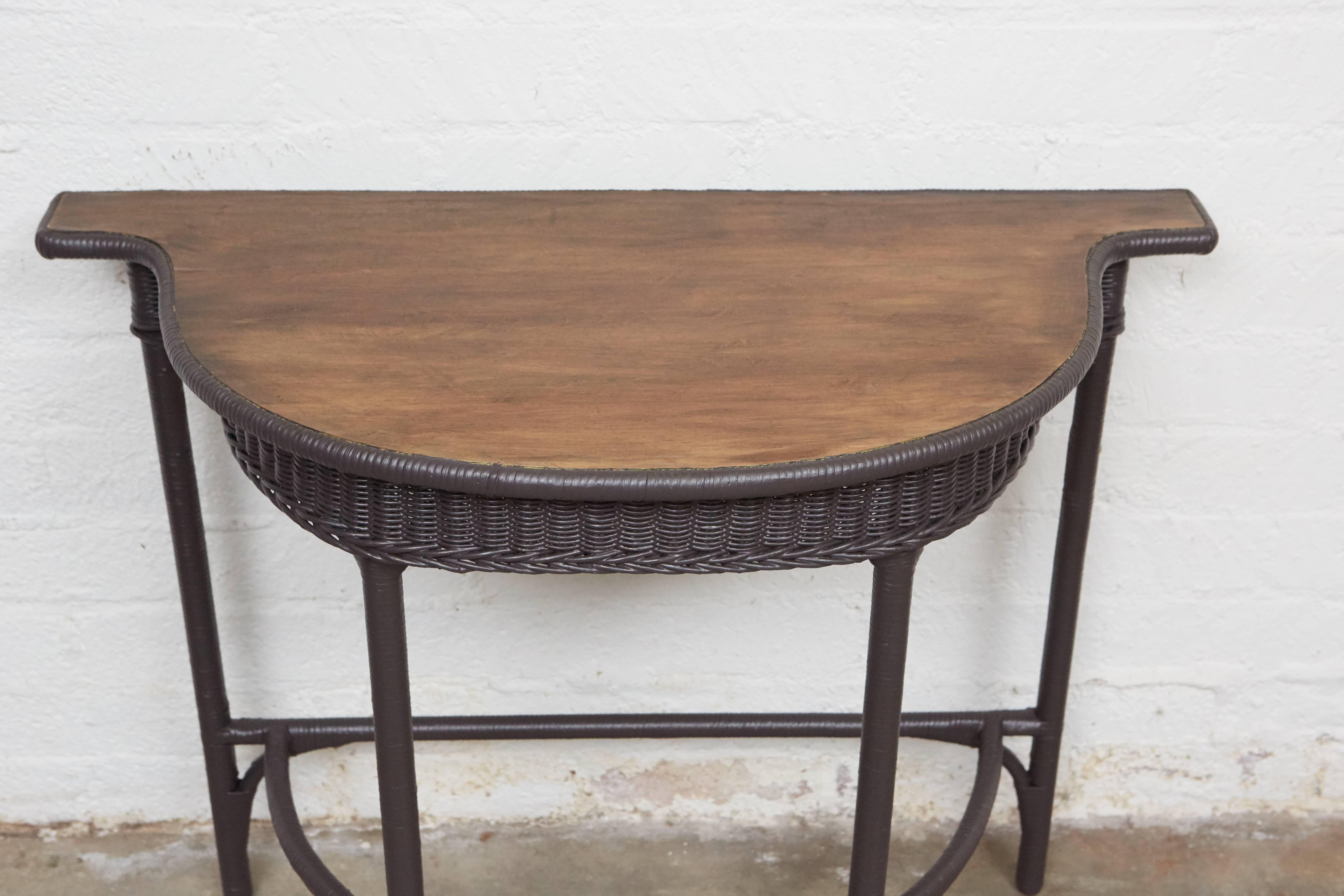 This wicker table has a really special shape with a nice oak top. The wicker skirt, legs and supports are painted with ash brown Farrow & Ball paint that gives the piece a great look for a variety of settings. 

  