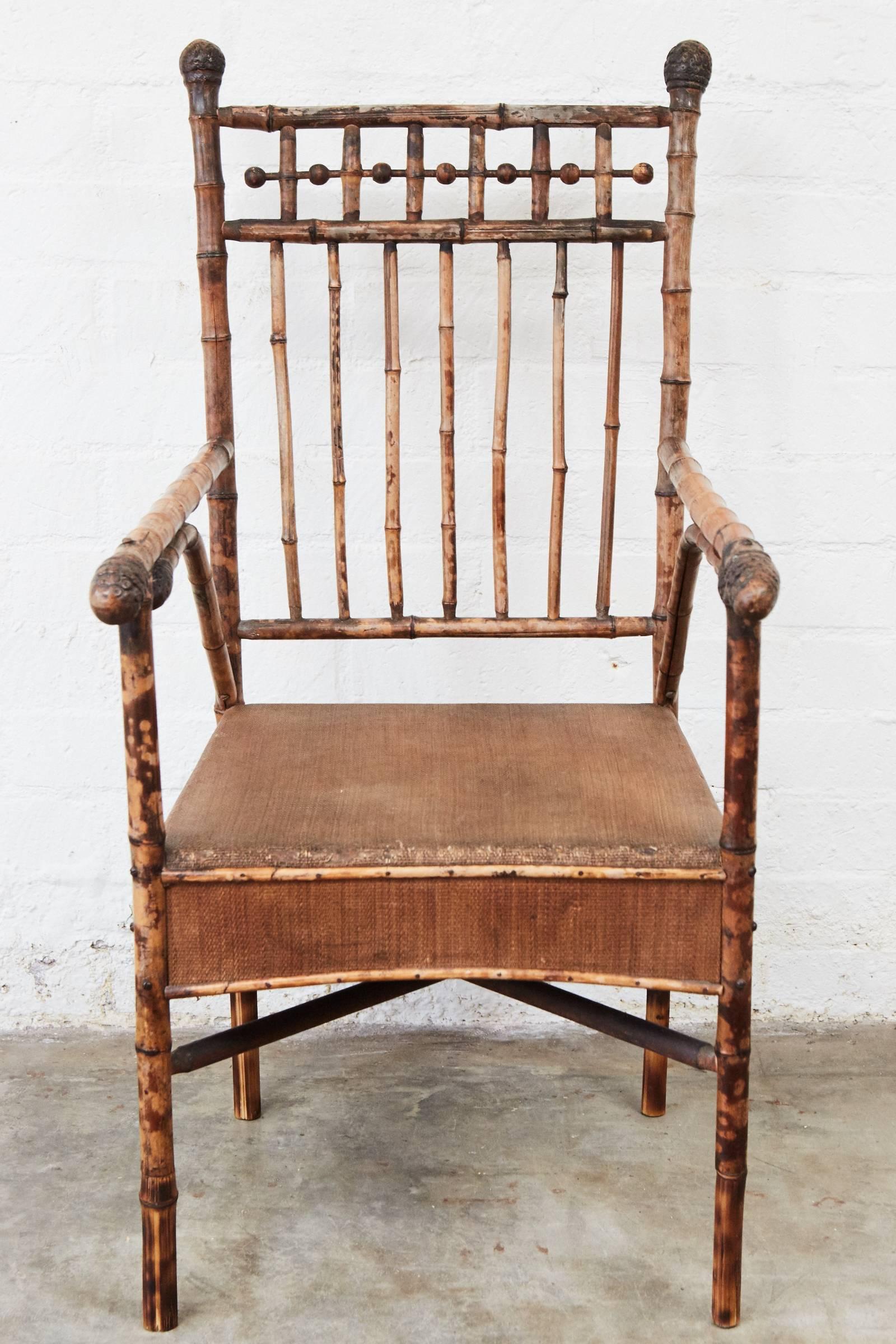 This wonderful bamboo American armchair has stick and ball elements, a woven mat seat and shaped bamboo roots as finials and armrests.