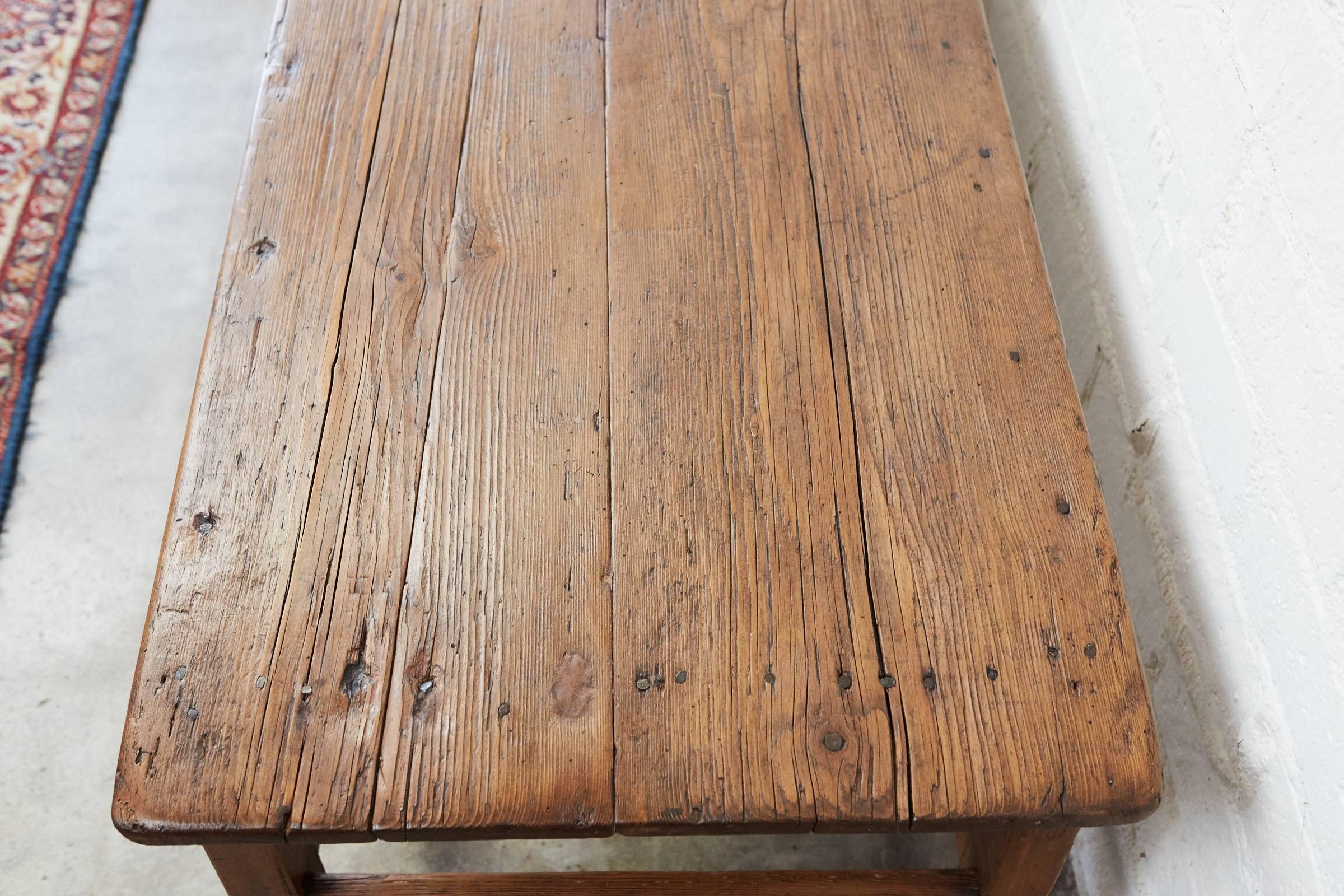 This long, narrow country table is of a good size having been a farm table converted later into a coffee table. The wood has signs of age and use consistent with a late 19th century piece. The legs are slightly tapered with nicely shaped