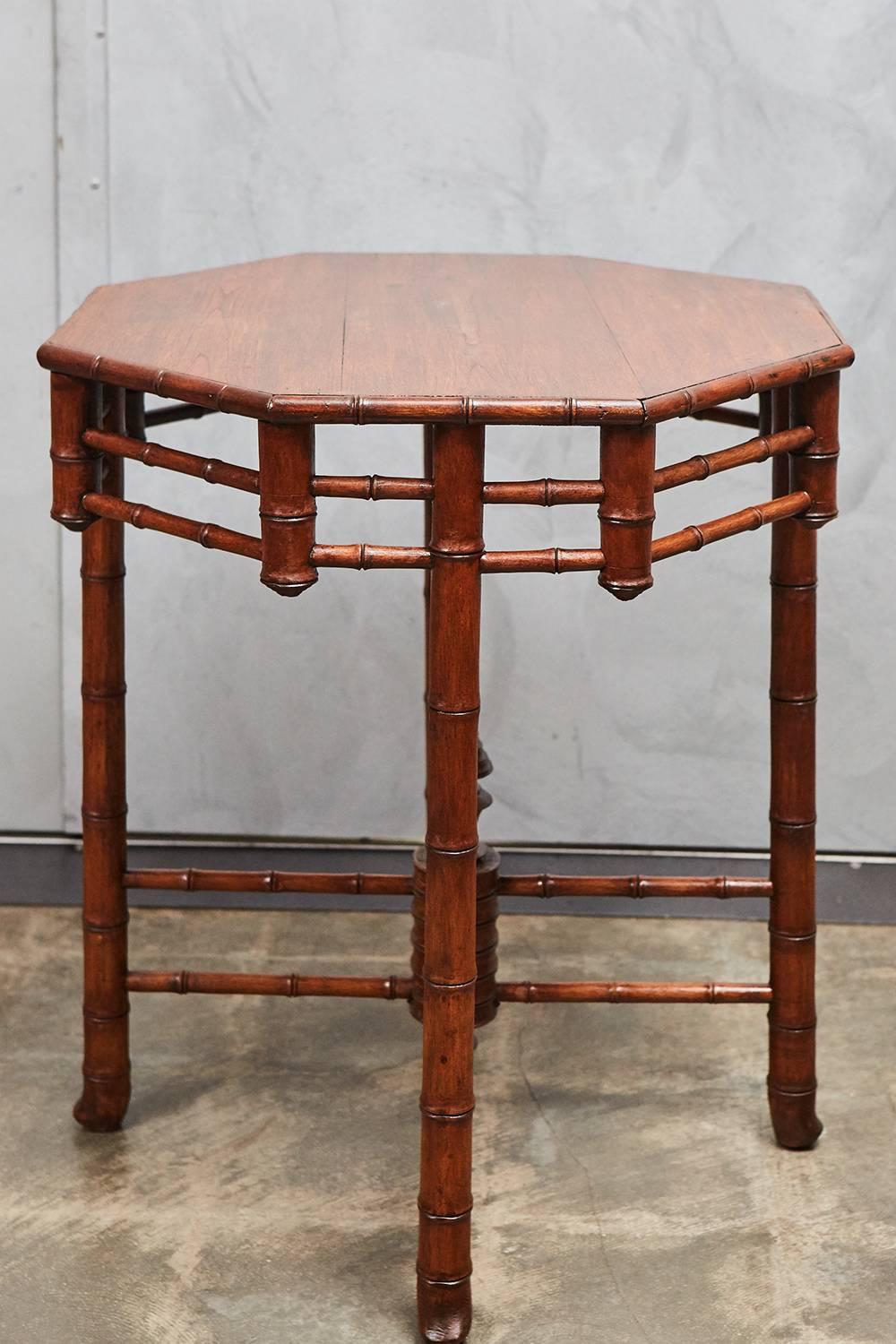 An unusual and interesting faux bamboo table, perhaps from one of the French settled dominions. The table stands on four legs, with two open work X-stretchers and an octagonal top with lattice like decorative skirting. Note the elaborately turned