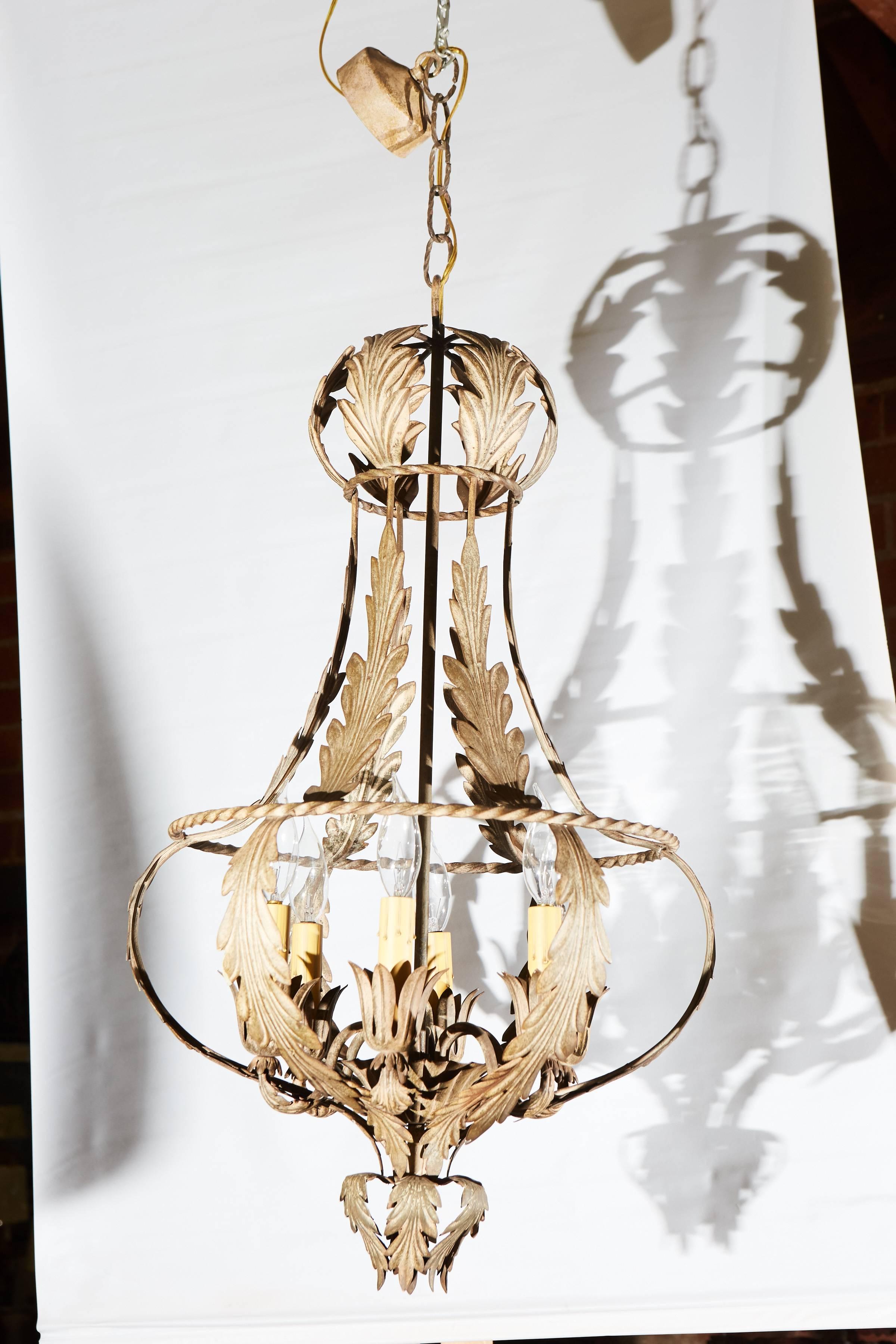 This is an Italian Mid-Century chandelier with six candle stick lights. The shape is round and decorated with acanthus leaves and aged to perfection.
