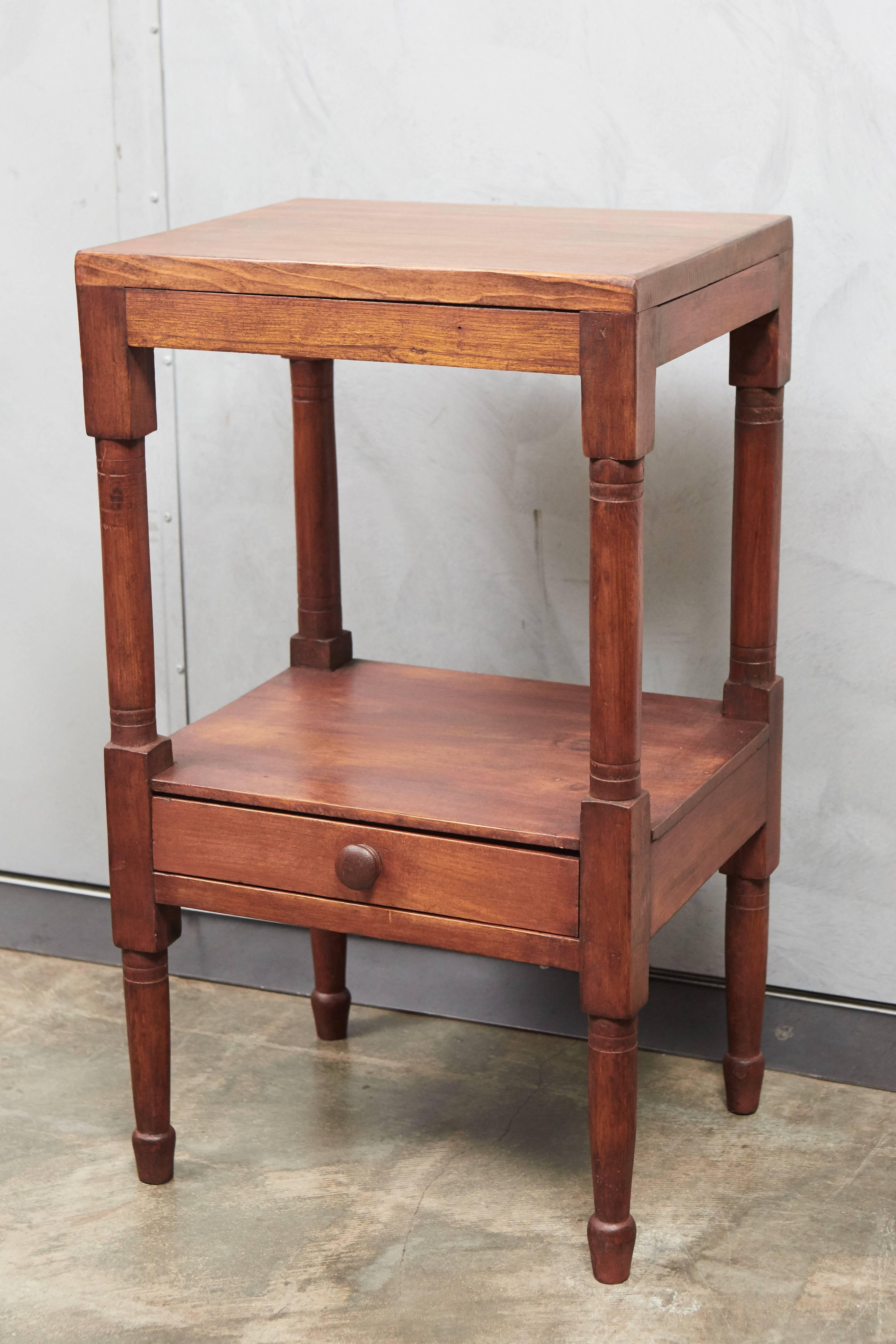 This nice little pine wash stand has turned legs and feet and one drawer in the lower shelf. The piece has a replaced top and is ready for use in a variety of settings.