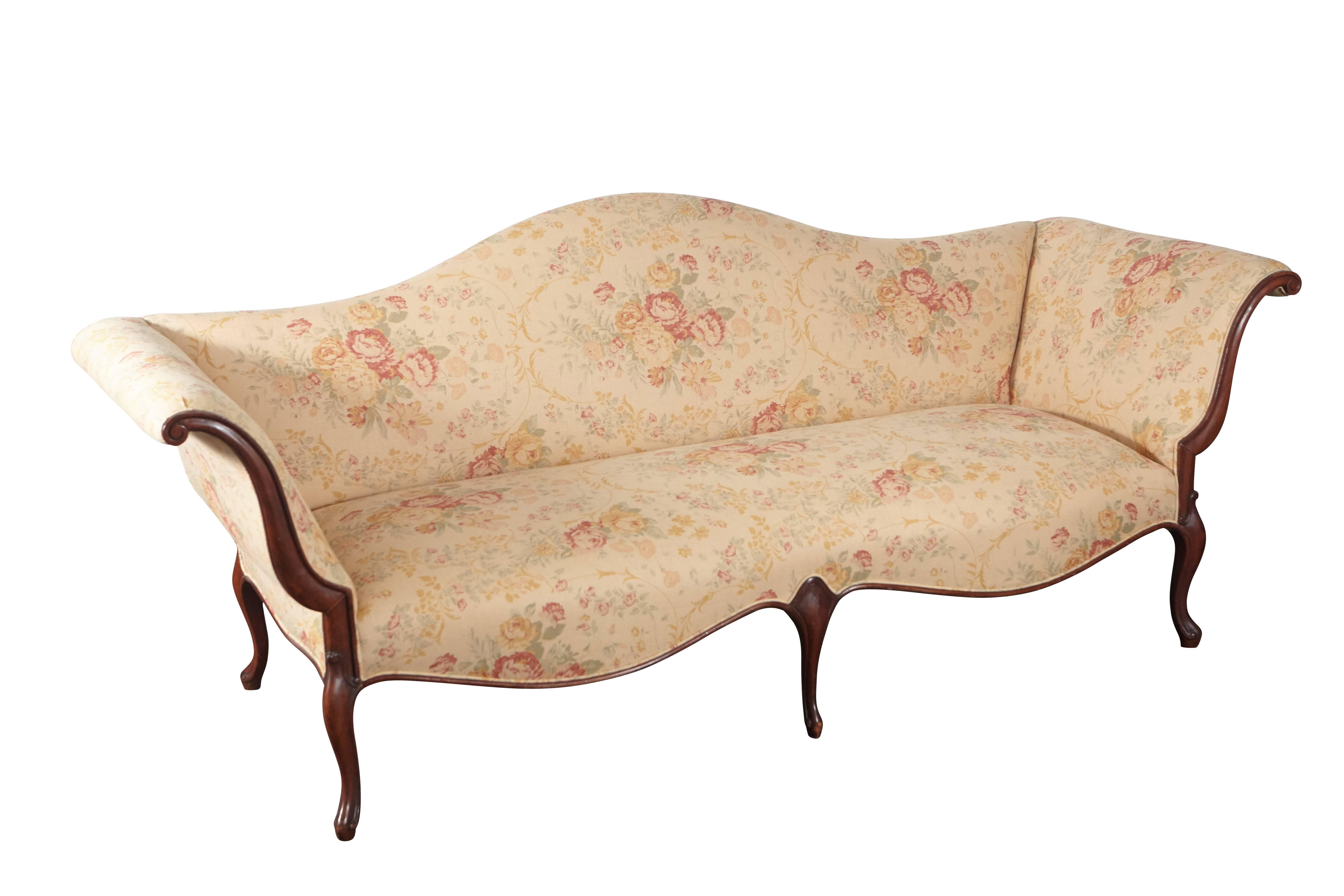 This wonderful canapé is of exceptional size with elegantly shaped bones that create a breathtaking view from any angle. The piece has been newly upholstered in linen floral fabric. The arms have a uniquely beautiful shape, opening to the seat in on