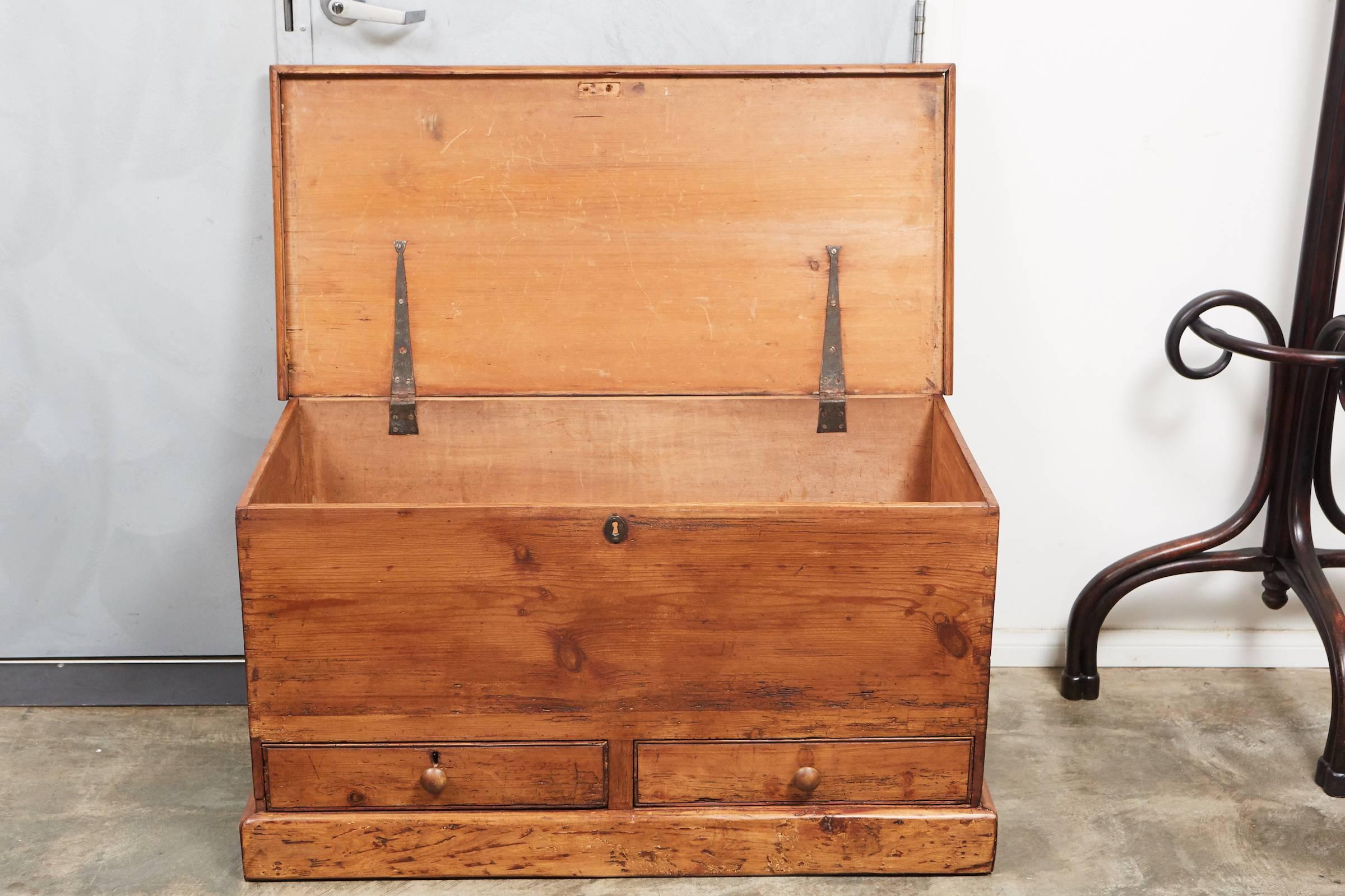 This handsome antique pine blanket box has two drawers and a stepped base. The handcrafted construction dates it to the early 19th century.
  
