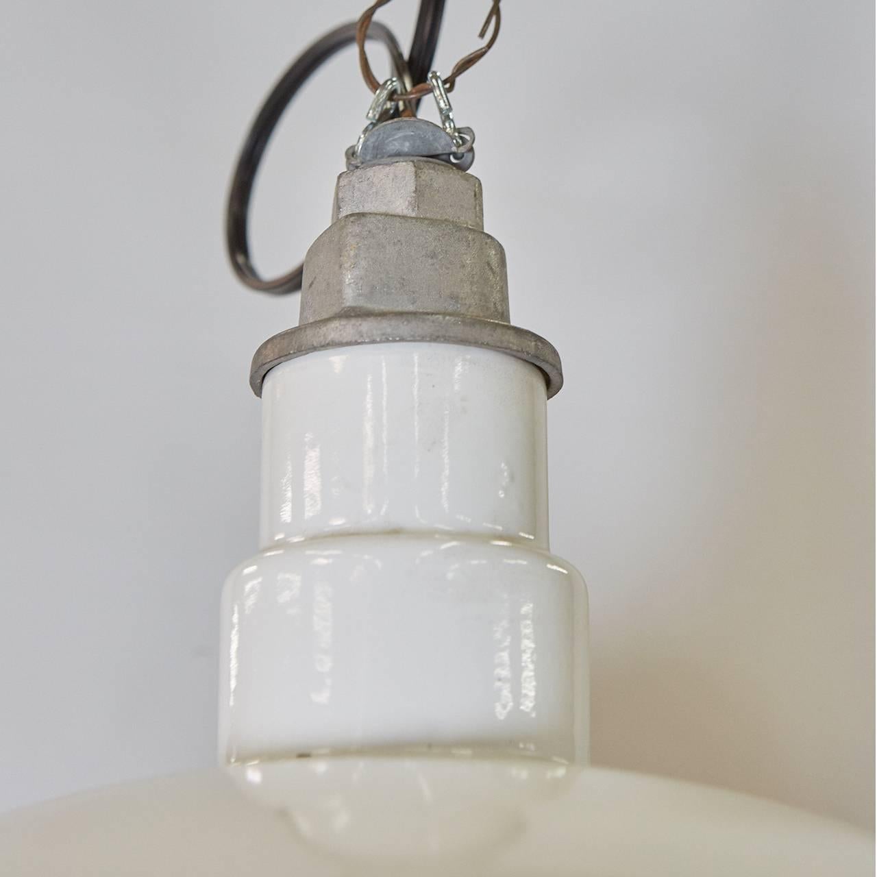 We have two pairs of these white enameled metal lamps. They have labels from the Quadrangle Manufacturer Corporation from Chicago. The standard dome reflector style was being made in 1930 (according to an archived catalog).