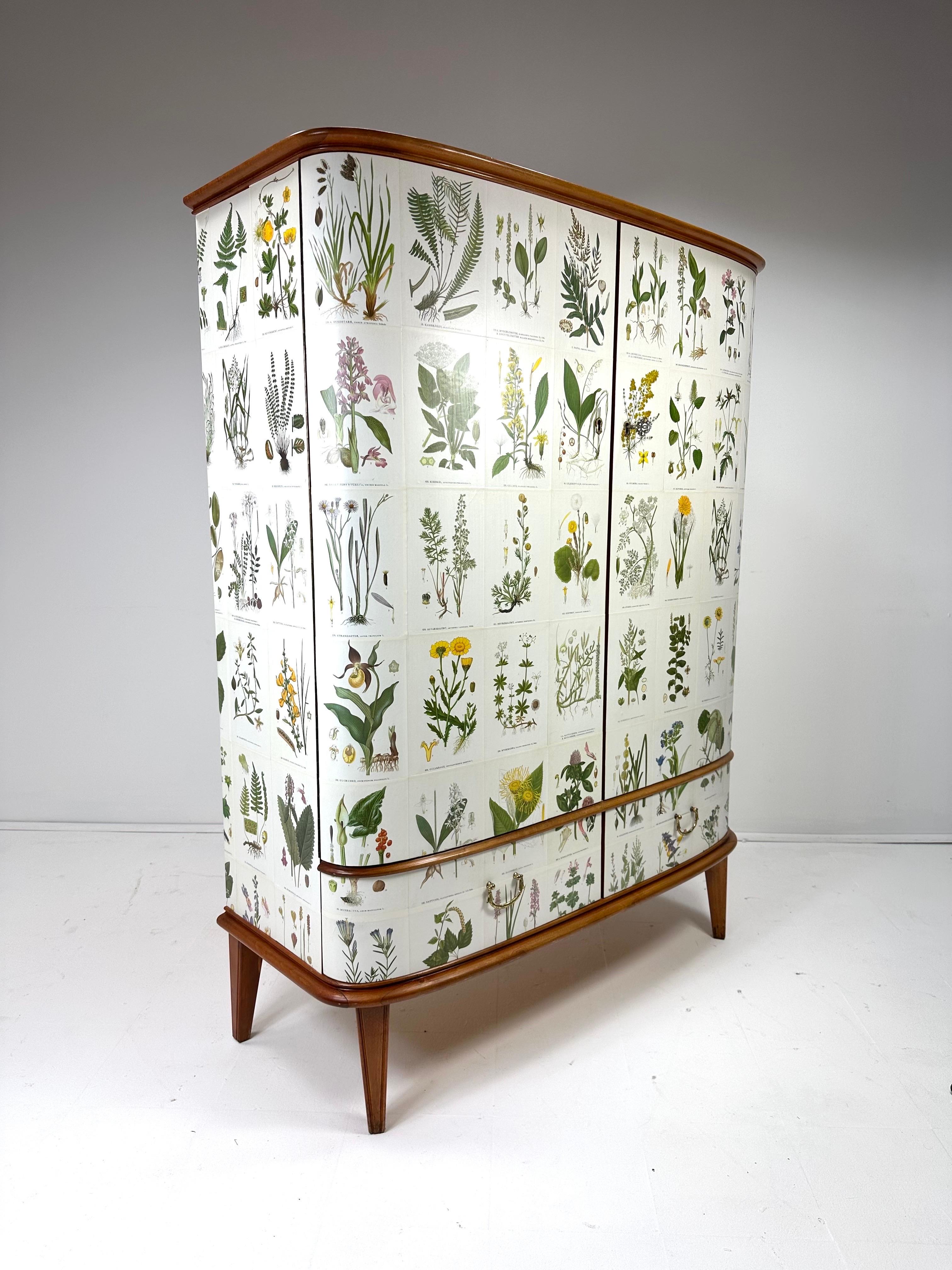 Armadio svedese a fronte curva degli anni '50, in seguito tappezzato con le illustrazioni di C.C. Lindman libro Nordens Flora.

Il mobile è composto da 2 grandi ante che nascondono ripiani interni regolabili e 3 piccoli cassetti sul lato destro. 2