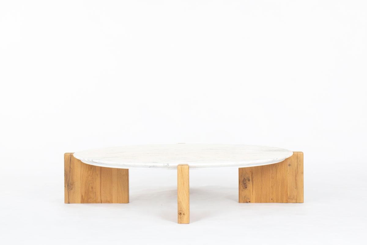 This striking round coffee table combines the natural sophistication of Calacatta marble with the warmth and character of handcrafted solid oak. The round marble top, sourced from the 1970s, features distinctive veining that makes each piece truly