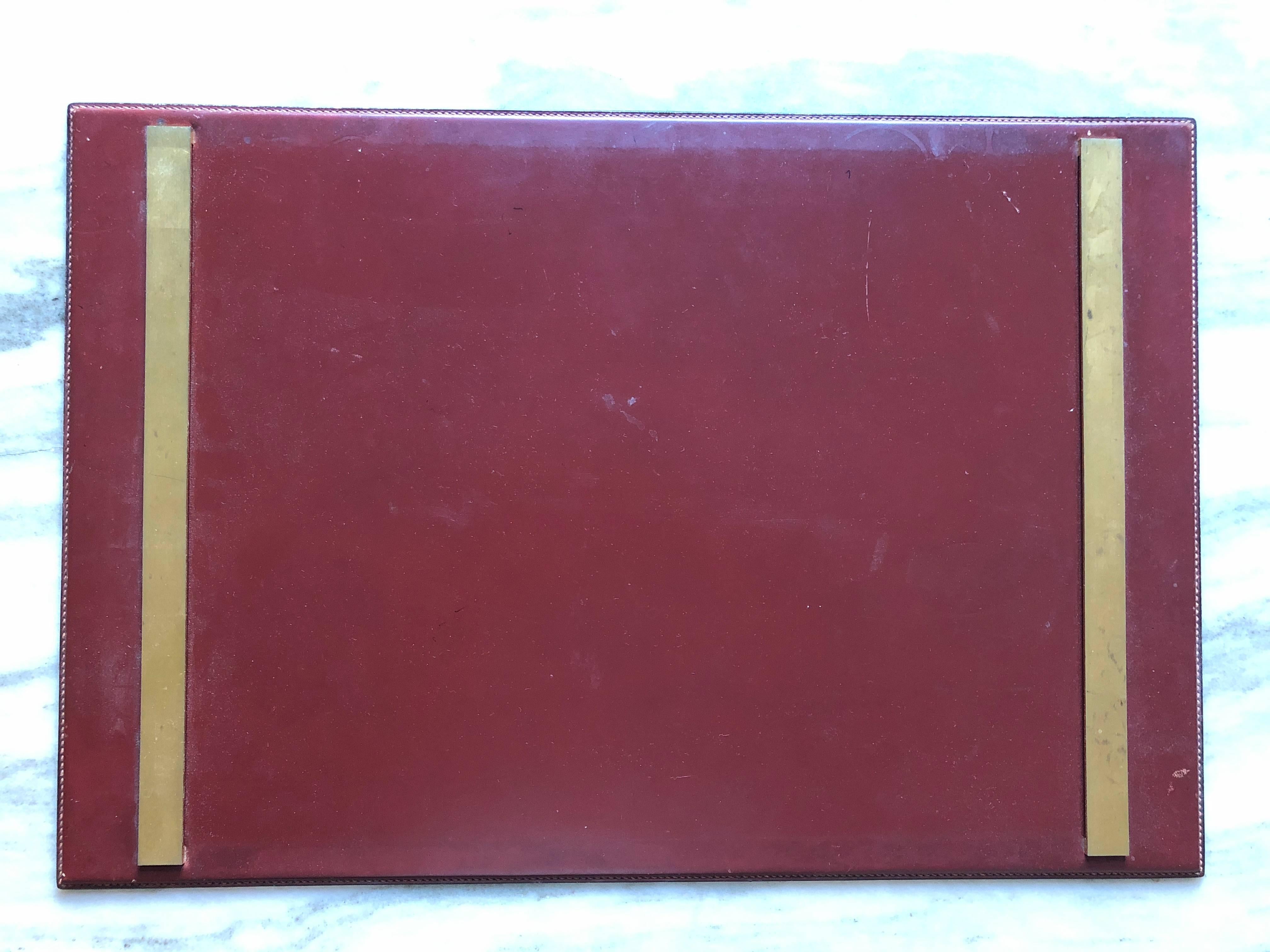 Stitched maroon leather with gilt bronze posts, circa 1960s. Gold foil stamp on verso.