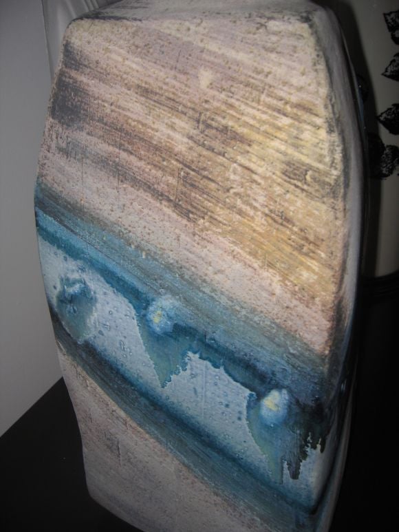 Large-scale hand thrown lamp base with glazes of blue, aqua, and yellow. The cord hole has never been drilled, and base has previously been displayed as an art object. We can have it configured into a lamp at the buyer's request.