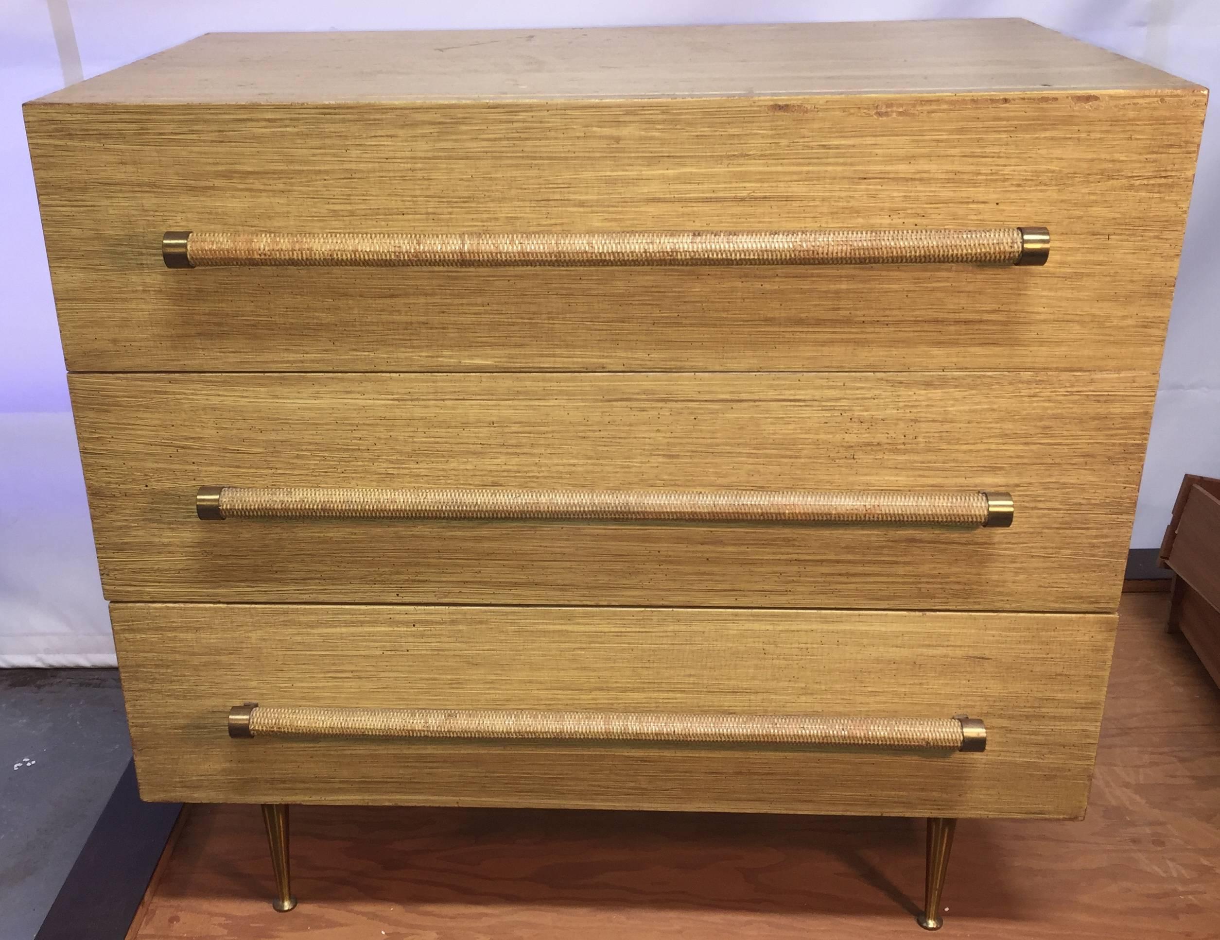 Classic chest for Widdicomb with cane or rattan-wrapped handles and brass feet is distinguished by an amazing period 1950 painted faux mahogany surface over the actual mahogany veneer. Cloth label to inside drawer.