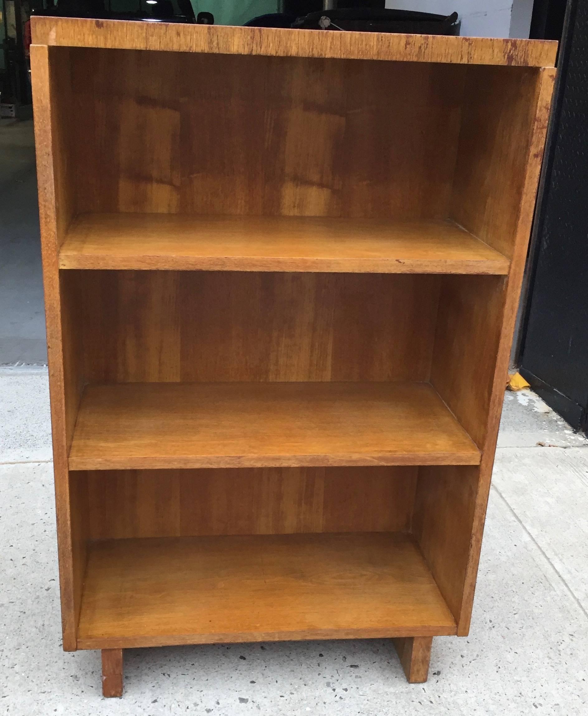 Simple modernist three-shelf bookcase on sleigh legs with lovely striped graining and light coursed surface. This unit is part of a custom designed library suite we acquired from the heirs of the family that hired Robsjohn-Gibbings in 1938 to