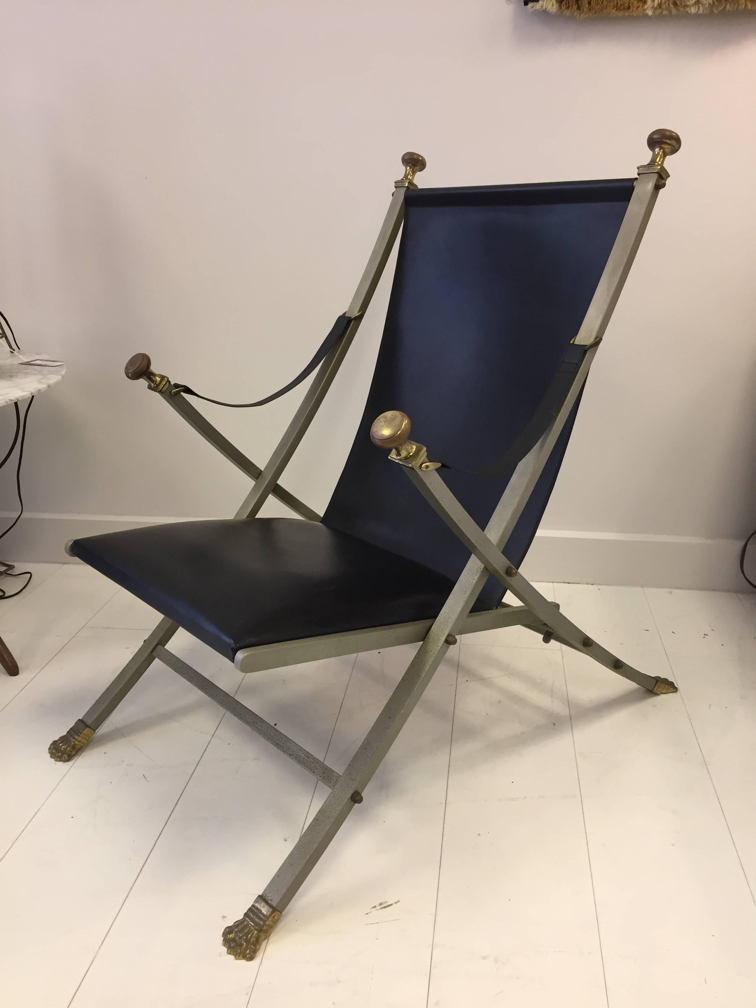 Chic folding chair with neoclassical styling. Leather seat and arm straps, with solid flat bar steel frame and bronze paw feet and knob handles. Produced in Italy in the style of Maison Jansen.