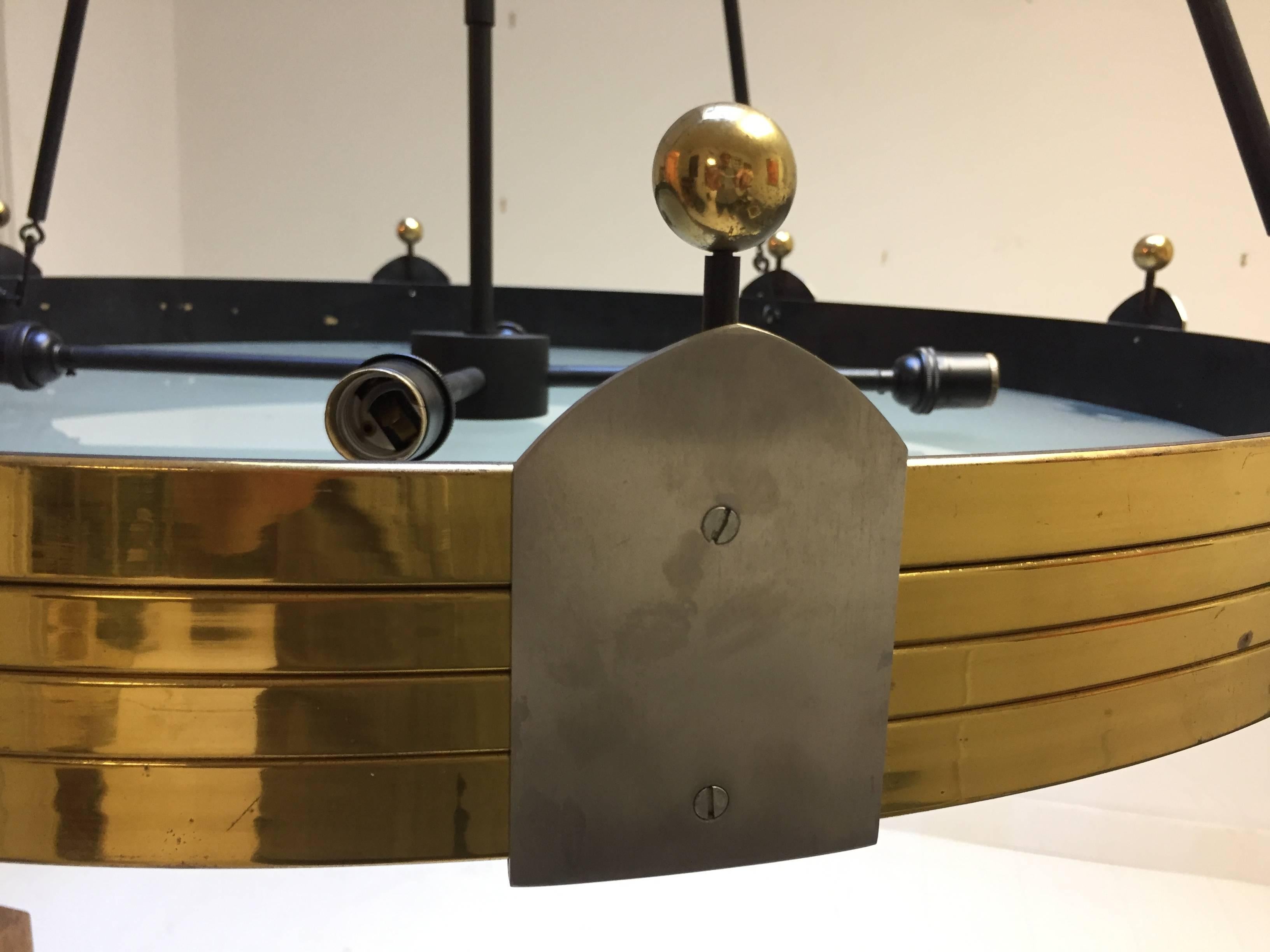 Massively scaled 1970s update of a 1940s design in solid brass with nickeled and enameled brass elements and frosted glass diffuser. The 36 inch diameter crown is suspended by four rods connecting to the canopy. Extremely heavy gauge brass and super