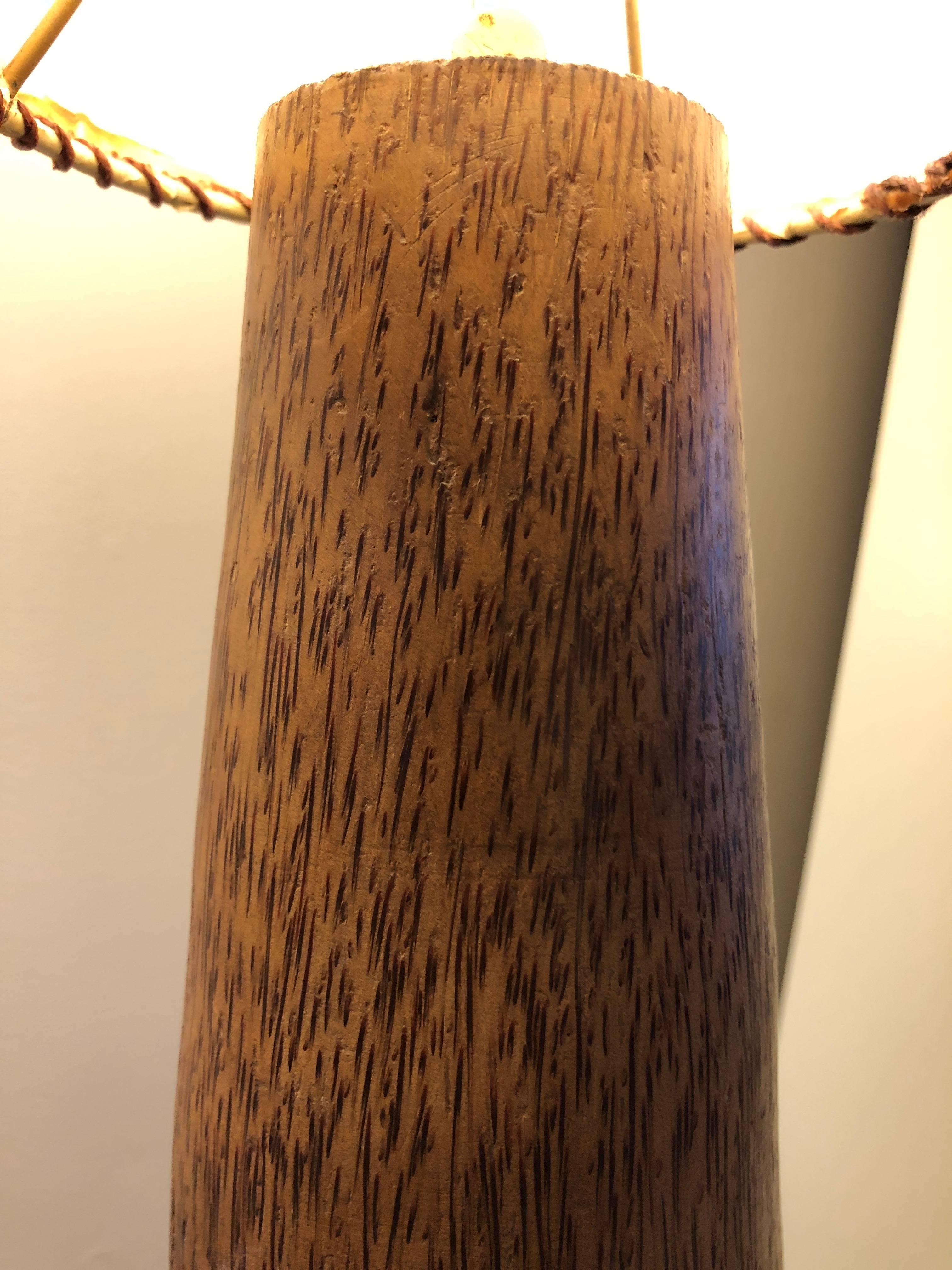 Solid lathe-carved tapering column of palm wood  with inverse cone shade. Unsigned, but likely a South American design. Floor dimmer on/off switch. Total height with shade is 84 inches with shade diameter 18