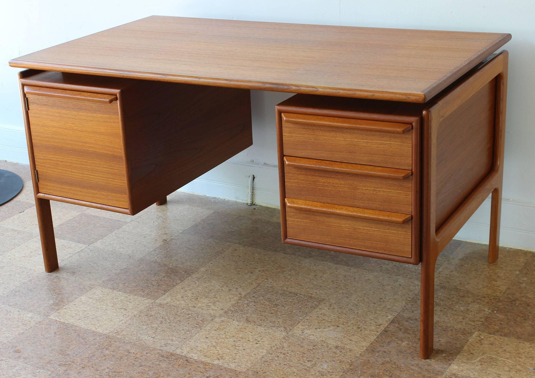 A Danish teak desk with floating top and drawers and cabinets in the style of Kai Kristiansen.

Measures: 19.25 inch opening between drawer/boxes.

