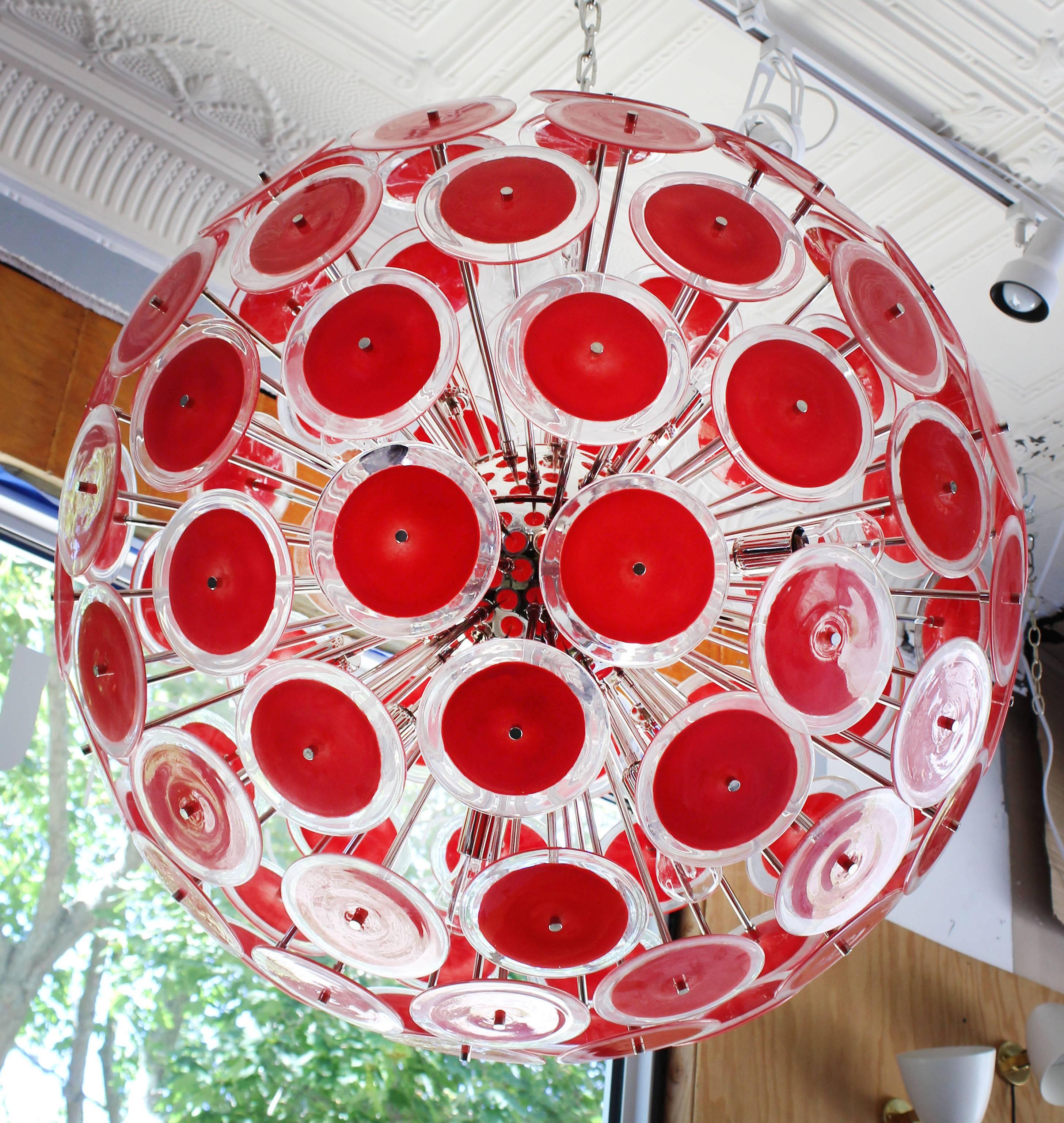 Spectacular modernist Vistosi disc sputnik chandelier. 95 round Murano coral red and clear glass disks and new chromed steel hardware. Each disk is 6