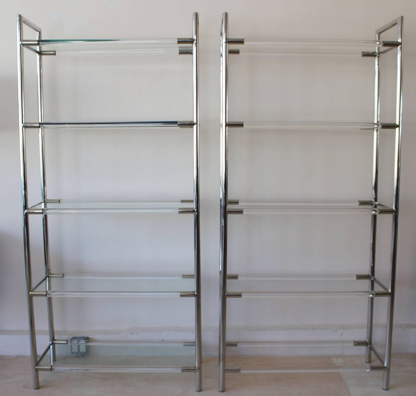 A handsome pair of Mid-Century chrome and Lucite etageres with tempered glass shelves in the manner of Charles Hollis Jones.