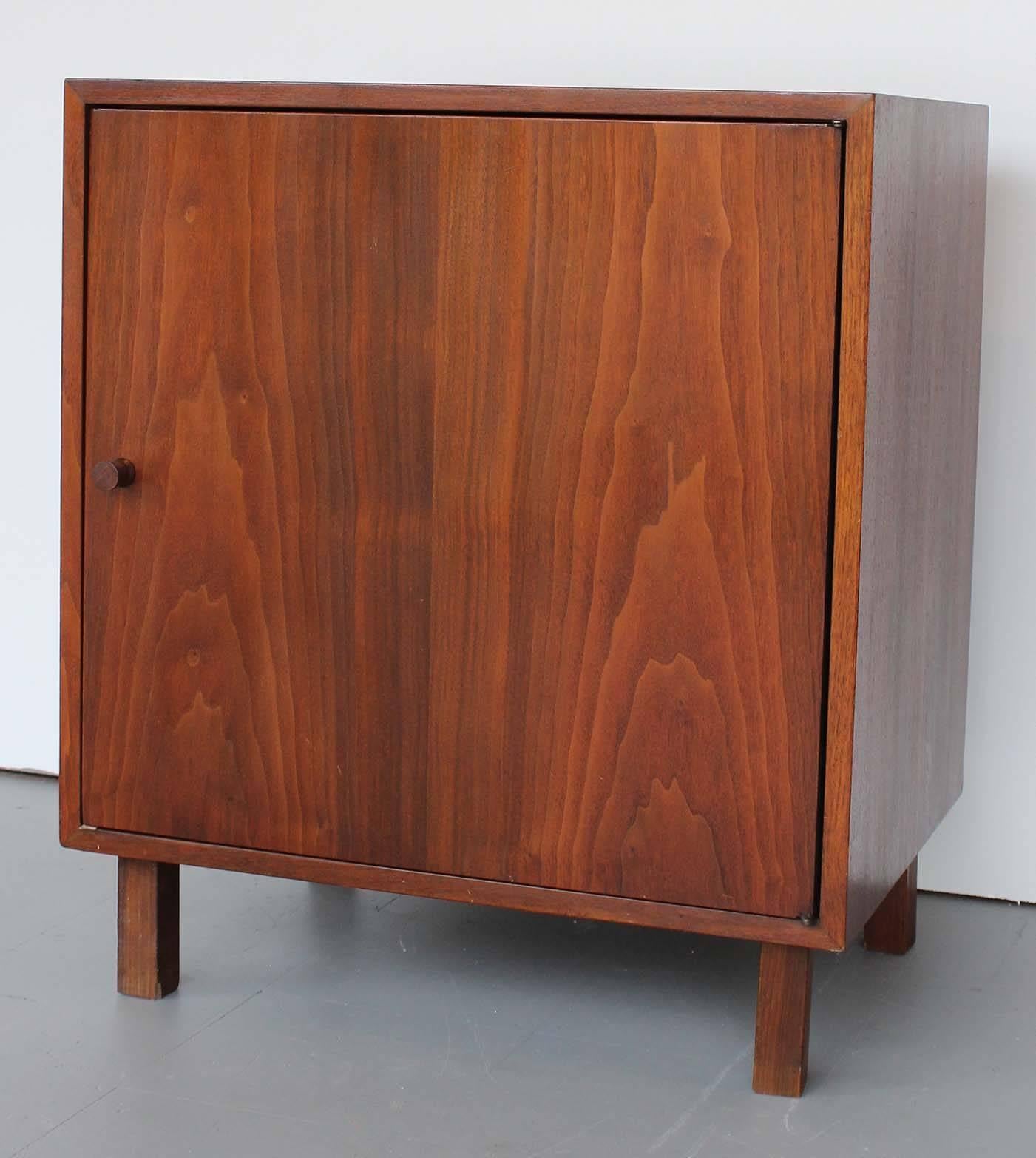 A pair of Mid-Century Danish walnut cabinets with walnut pulls and legs.

