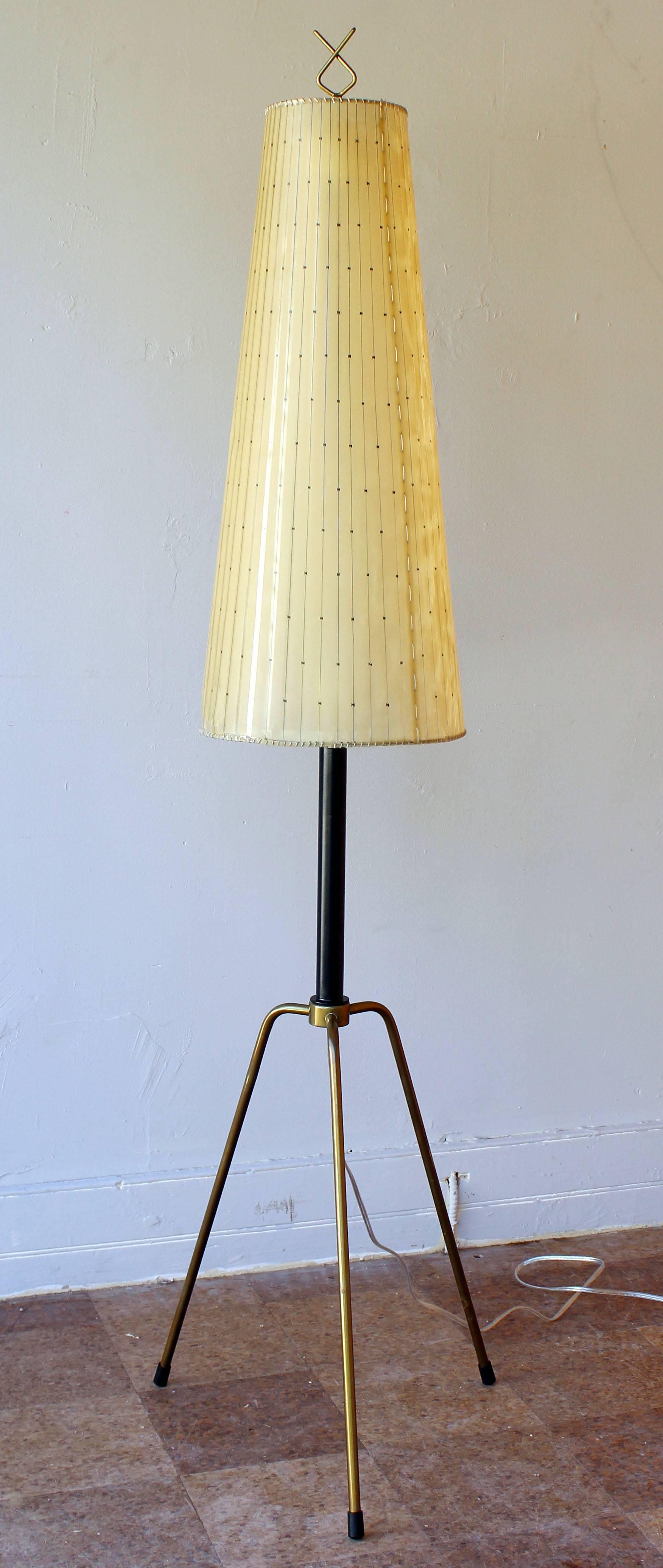 An early and rare Italian tripod floor lamp with solid brass legs and enameled metal neck and double socket details please refer to detail pictures. With original vellum shade and brass finial.

Complementary delivery within 30 miles.