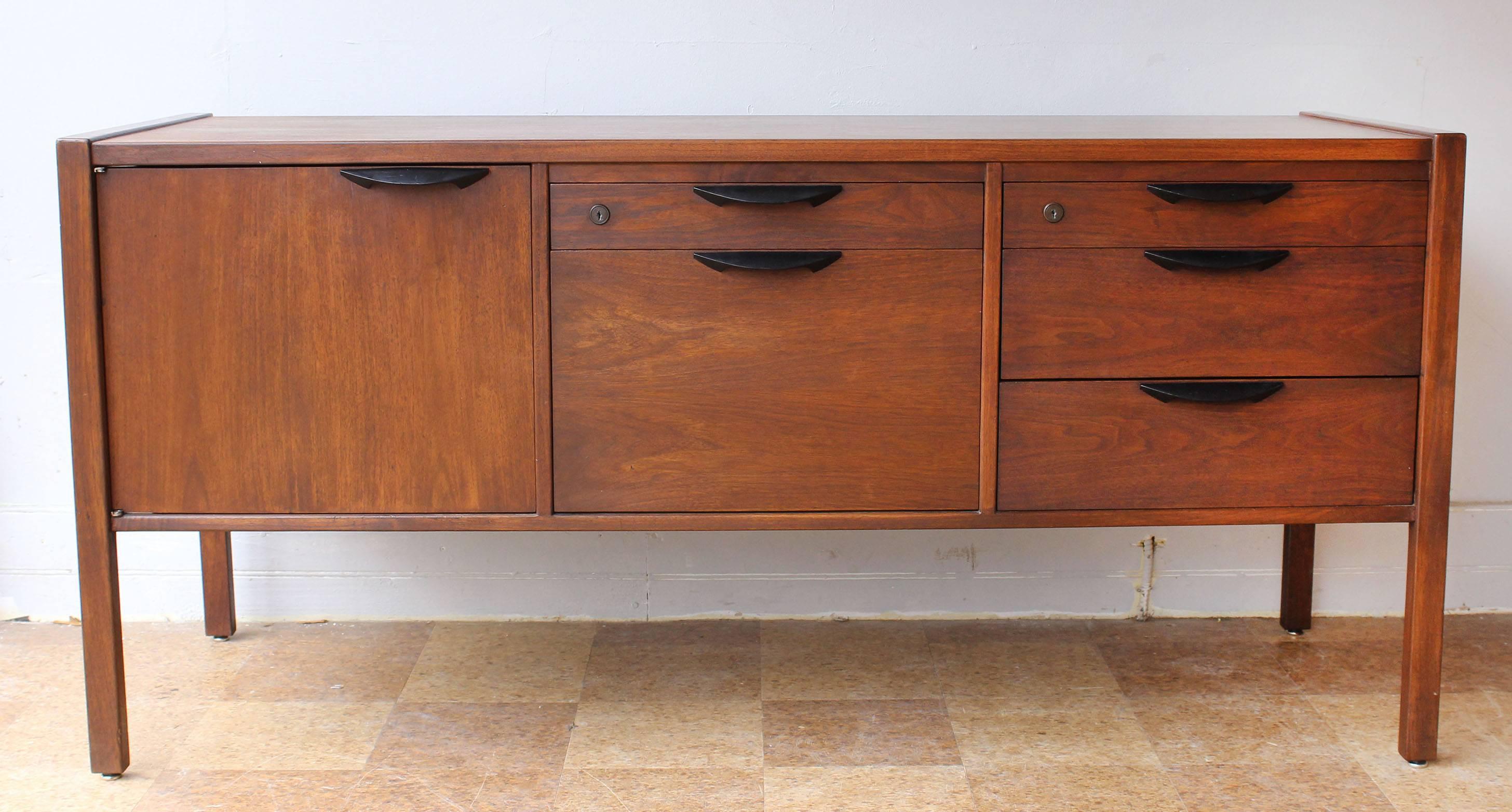 A pair of teak credenzas with enameled metal pulls designed by Jens Risom.

complementary shipping within 30 miles.