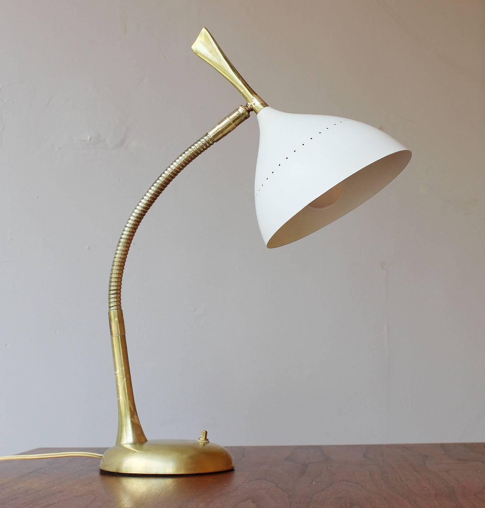 A patinaed brass and enameled metal adjustable gooseneck desk lamp with perforated shade, in the manner of Stillovo.

complementary delivery within 30 miles