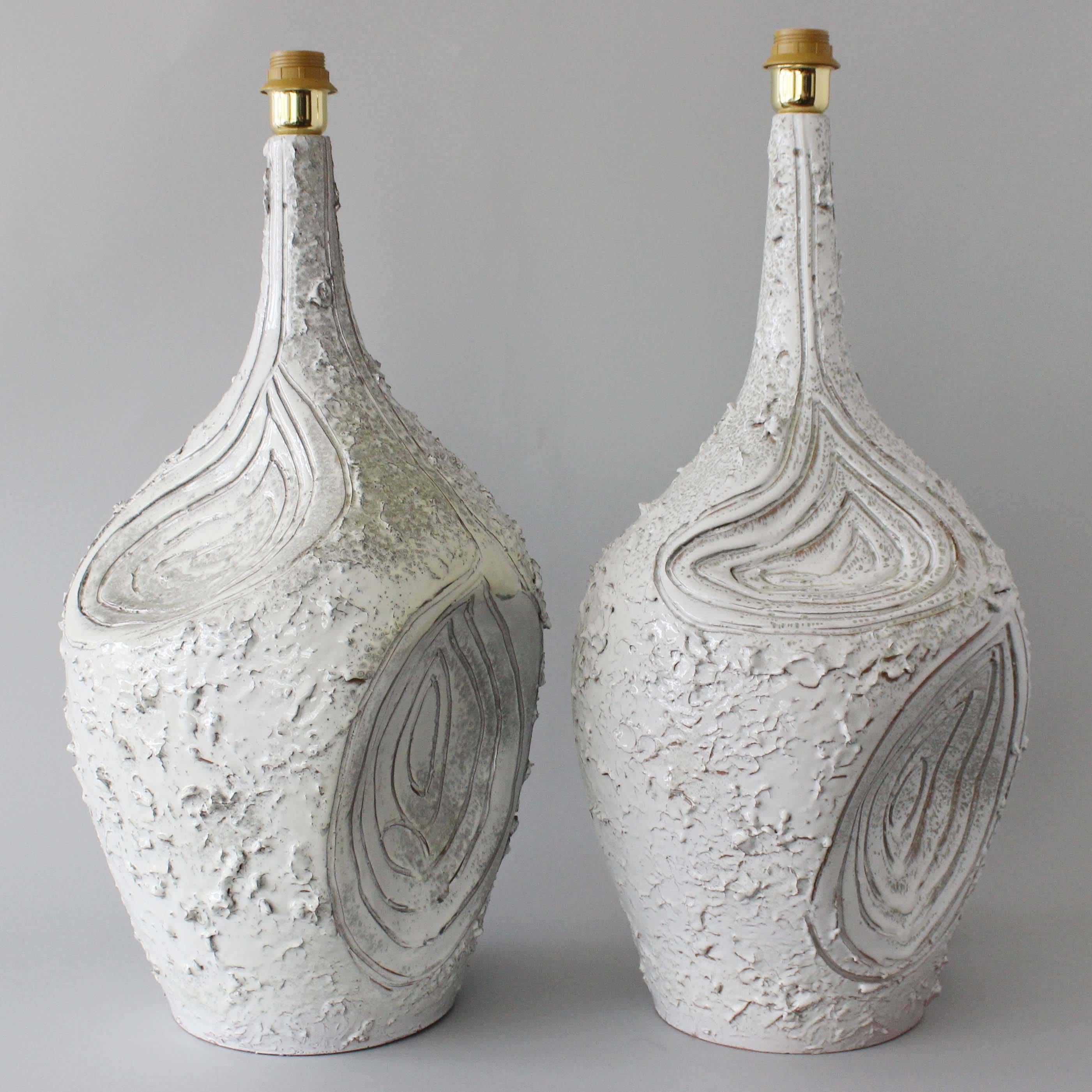 A large pair of textured, and glazed terra cotta lamps with incised concentric patterning, in the style of Guido Gambone.

   