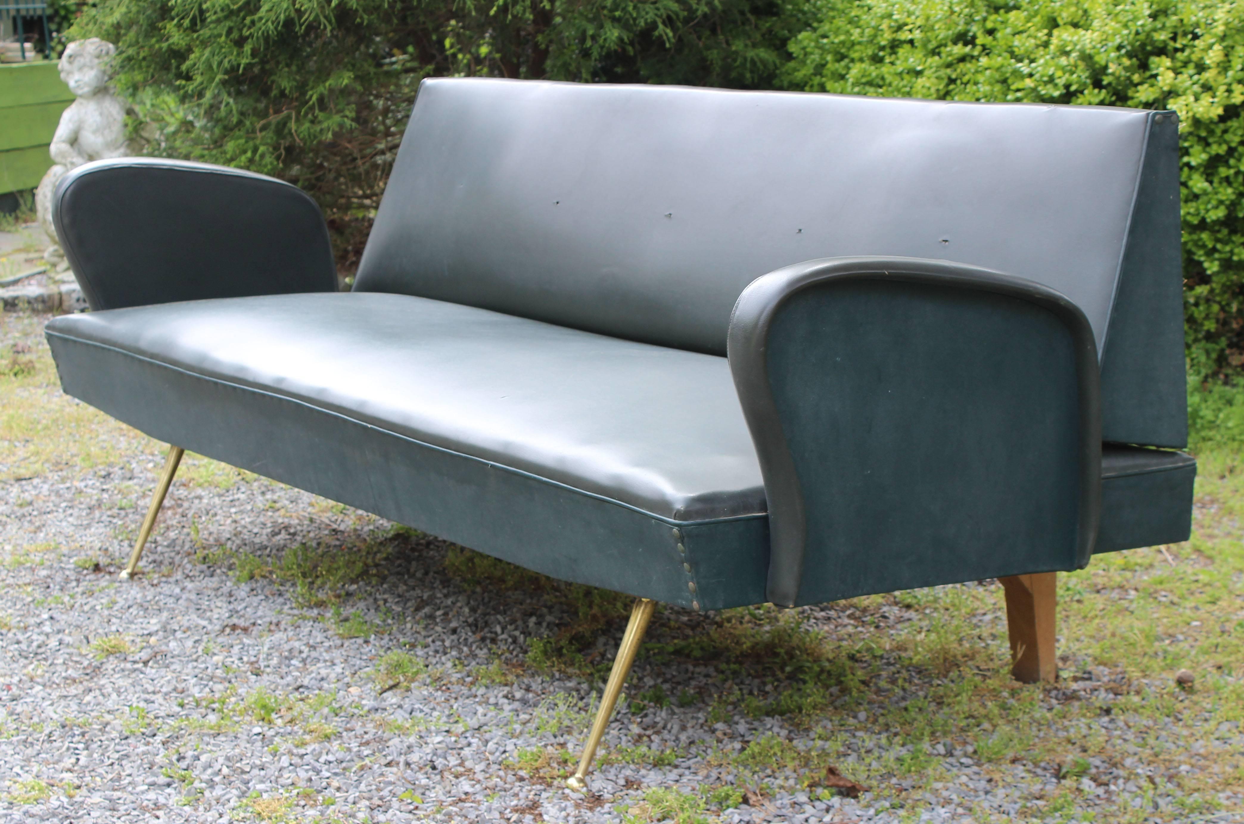 An Italian Mid-Century sofa or daybed in original vinyl upholstery, with brass leg details.