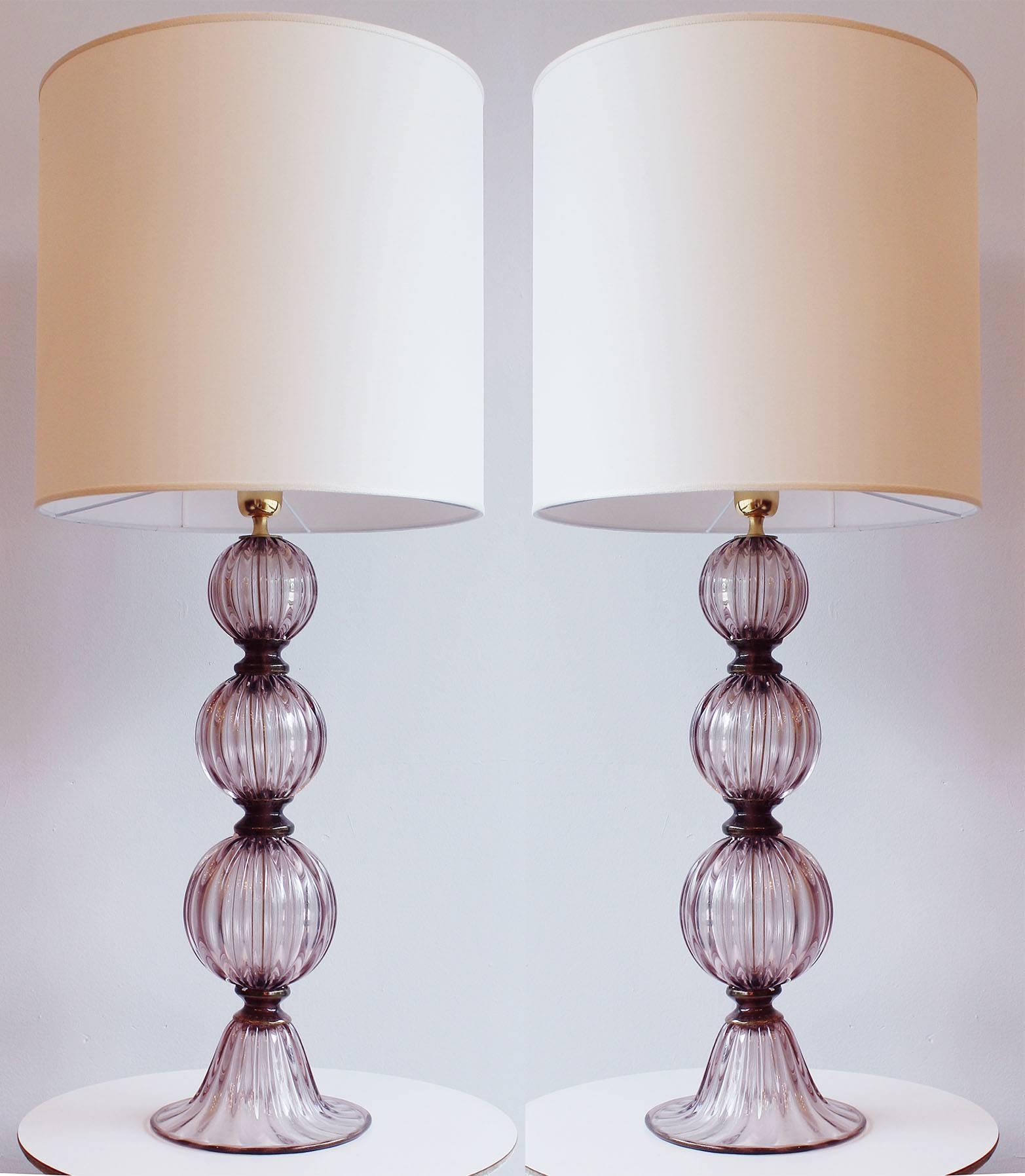 A pair of Murano all glass tassel lamps, with amethyst colored glass and gold accents. The lamps are signed Murano. 

Please note the height in description is the height to the socket, including brass detail, without the shade. The shades are not